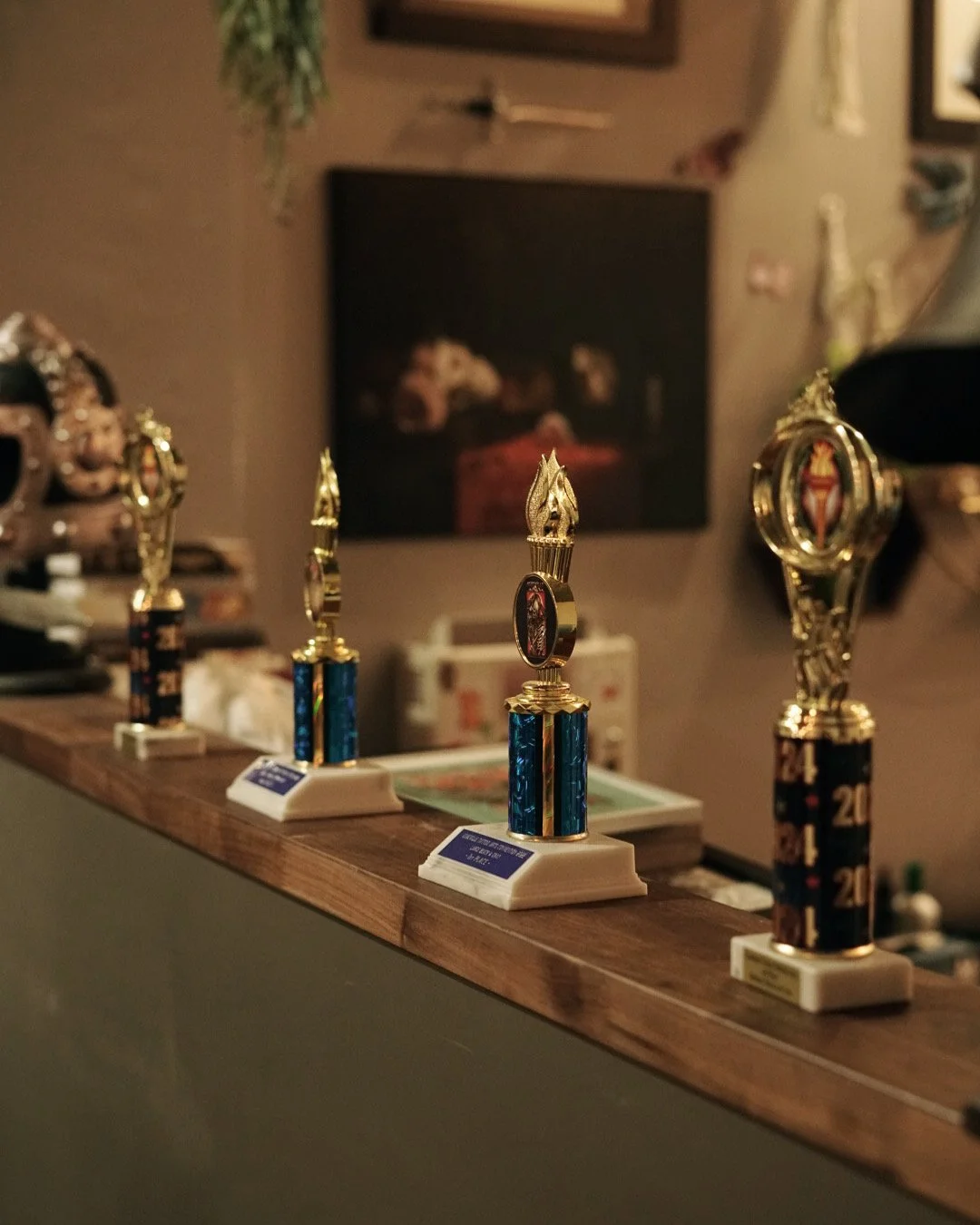 Black Craft Tattoo Collective tattoo awards displayed on a wooden surface.