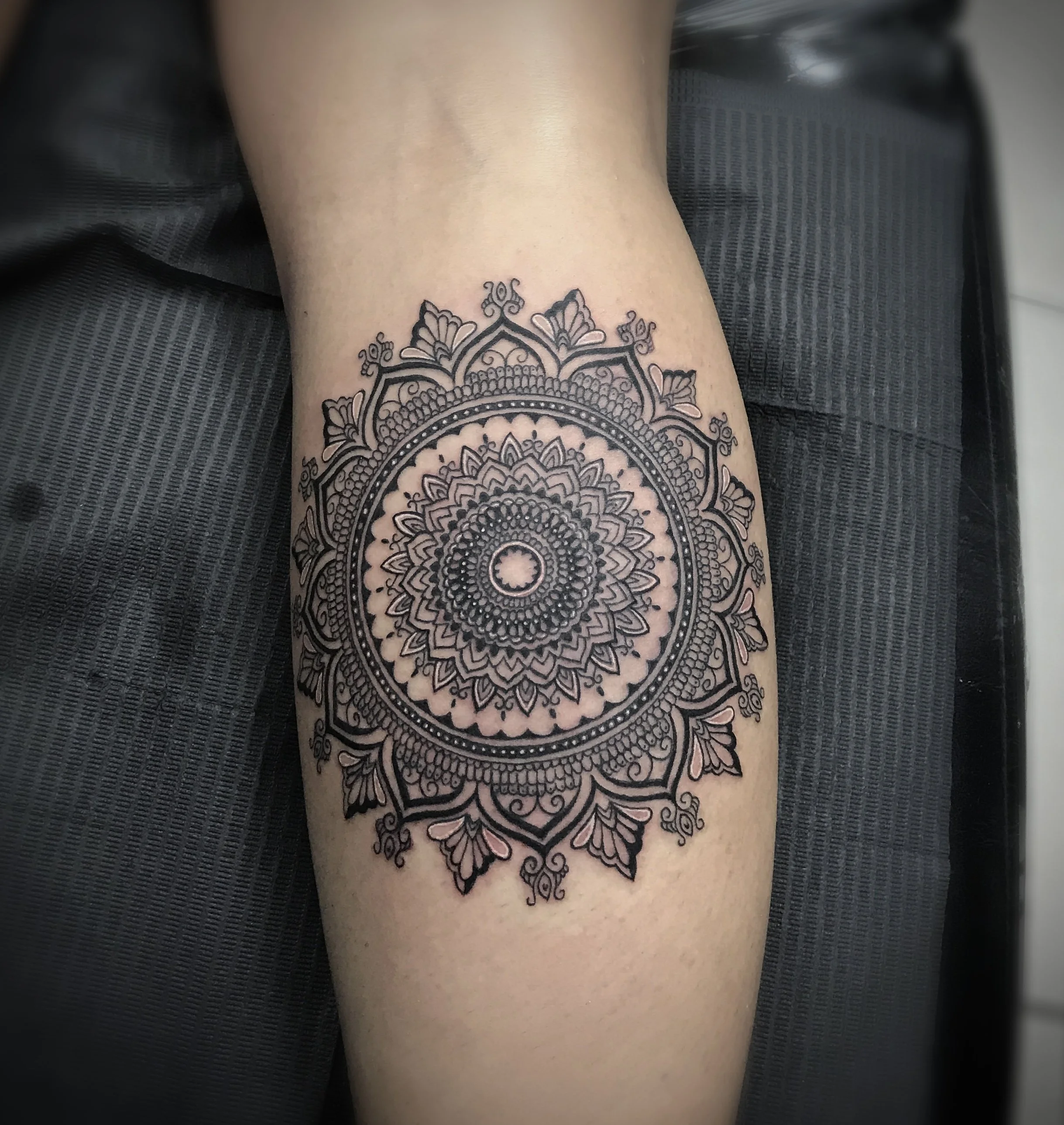 Detailed blackwork floral mandala forearm tattoo by Luis Dajer.