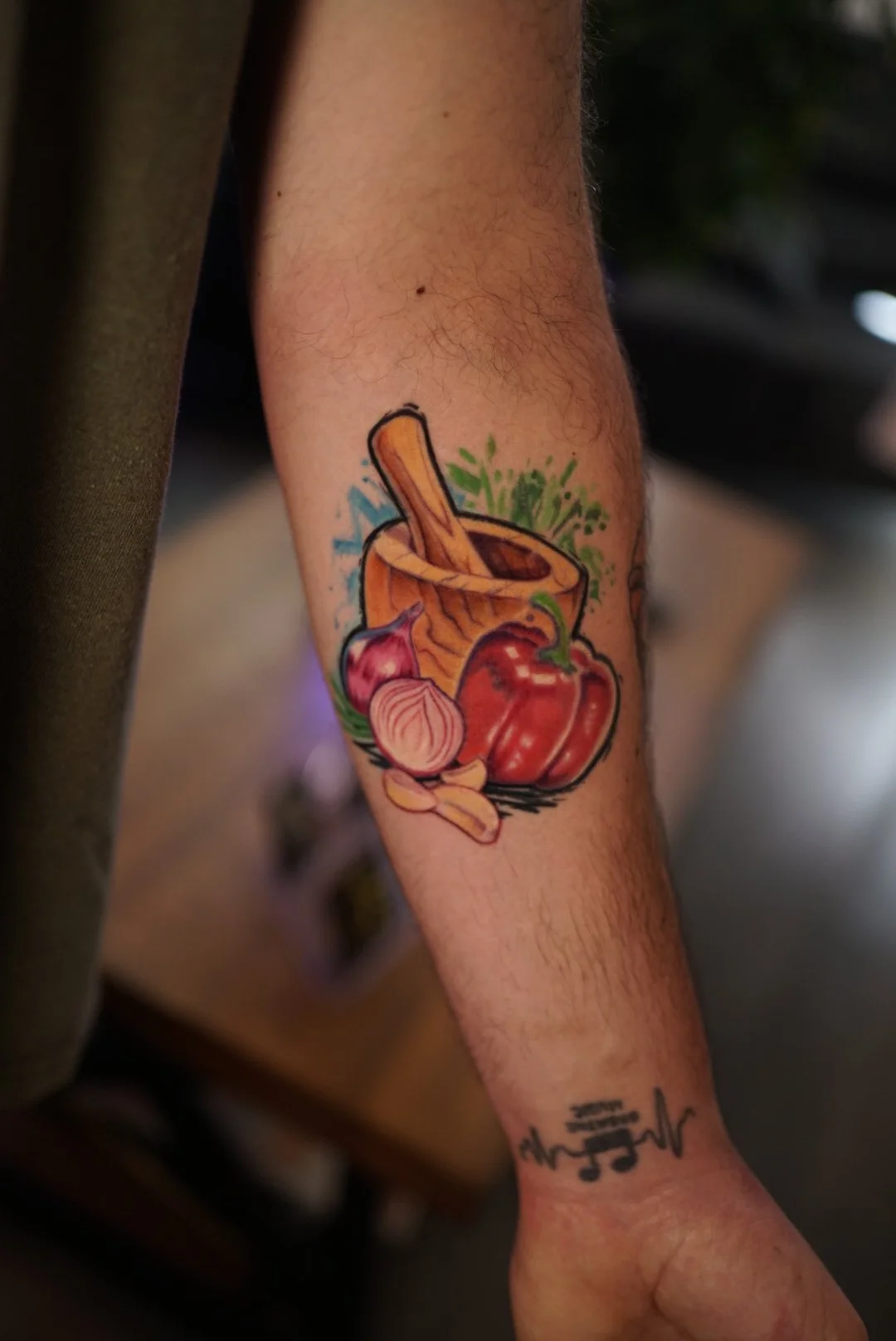 Color cooking-themed forearm tattoo with mortar, onion and peppers by Luis Dajer.