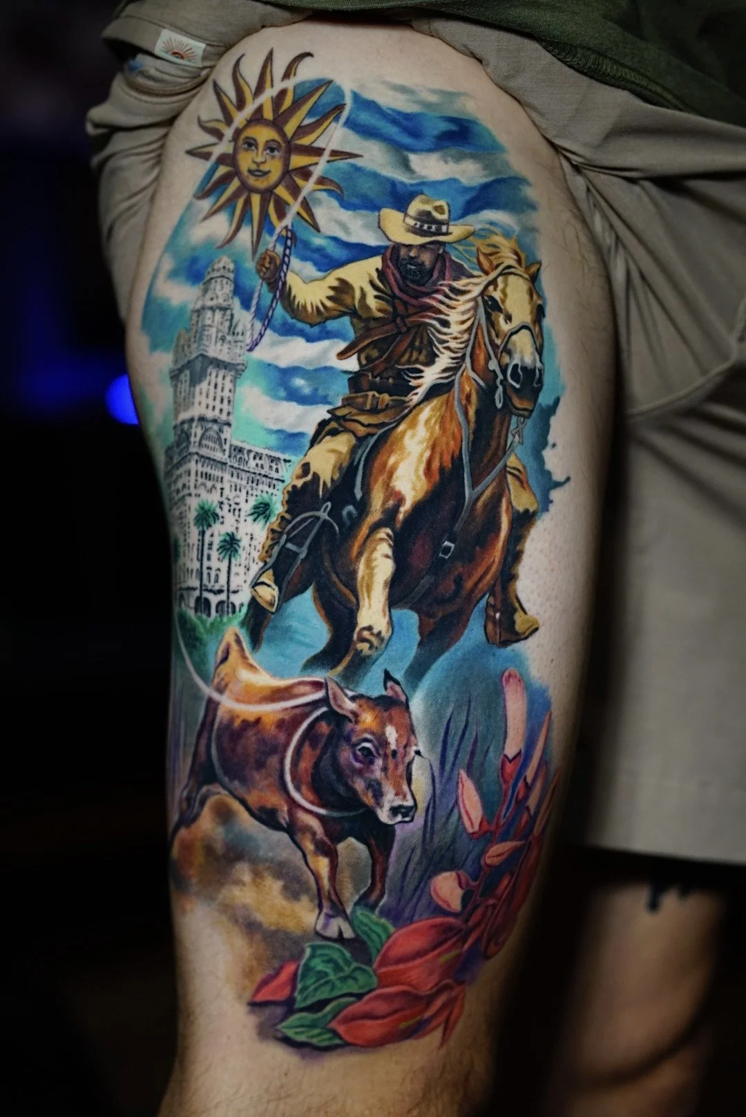 Color cowboy riding a horse with a dog and Western landscape tattoo.