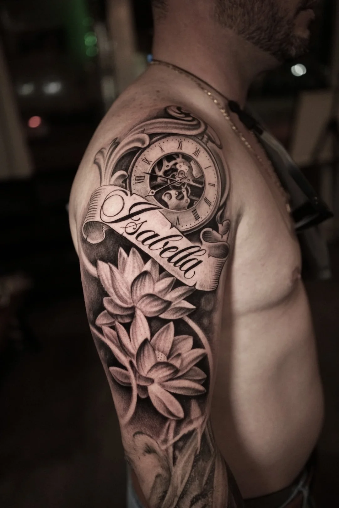 Black-and-gray pocket watch, lotus flower and Salvador banner tattoo by Luis Dajer.