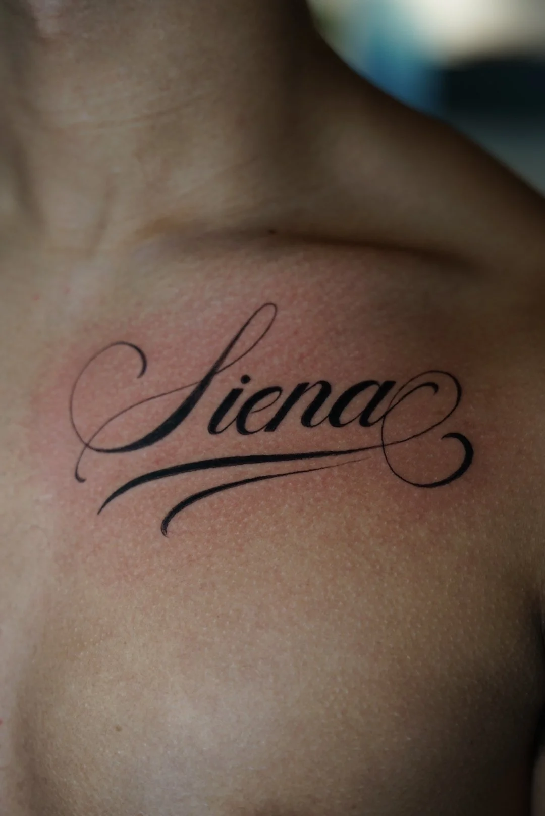 Elegant Liena script collarbone tattoo by Luis Dajer.