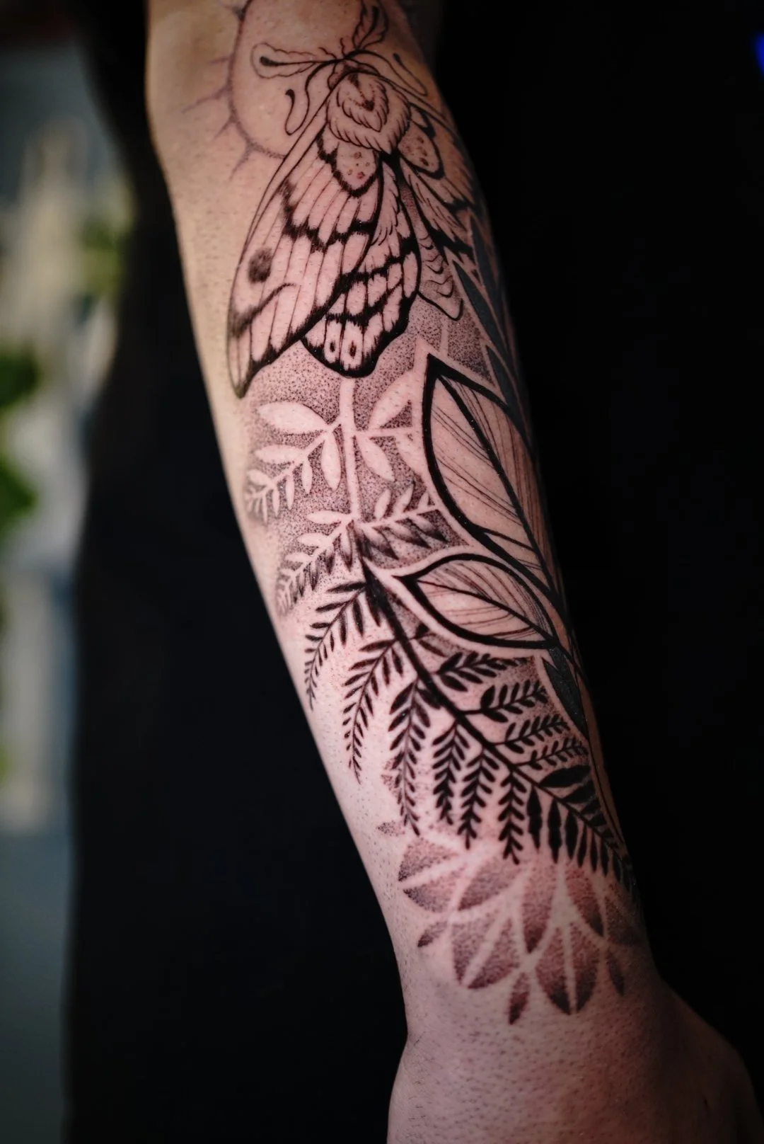 Detailed bee and botanical arm tattoo by Luis Dajer at Black Craft Tattoo Collective.