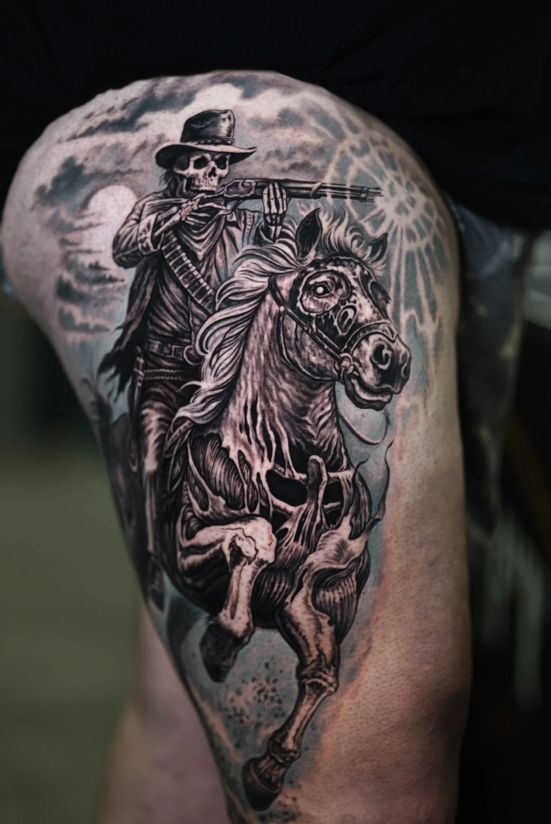 Black-and-gray skeleton cowboy riding a rearing horse under storm clouds.