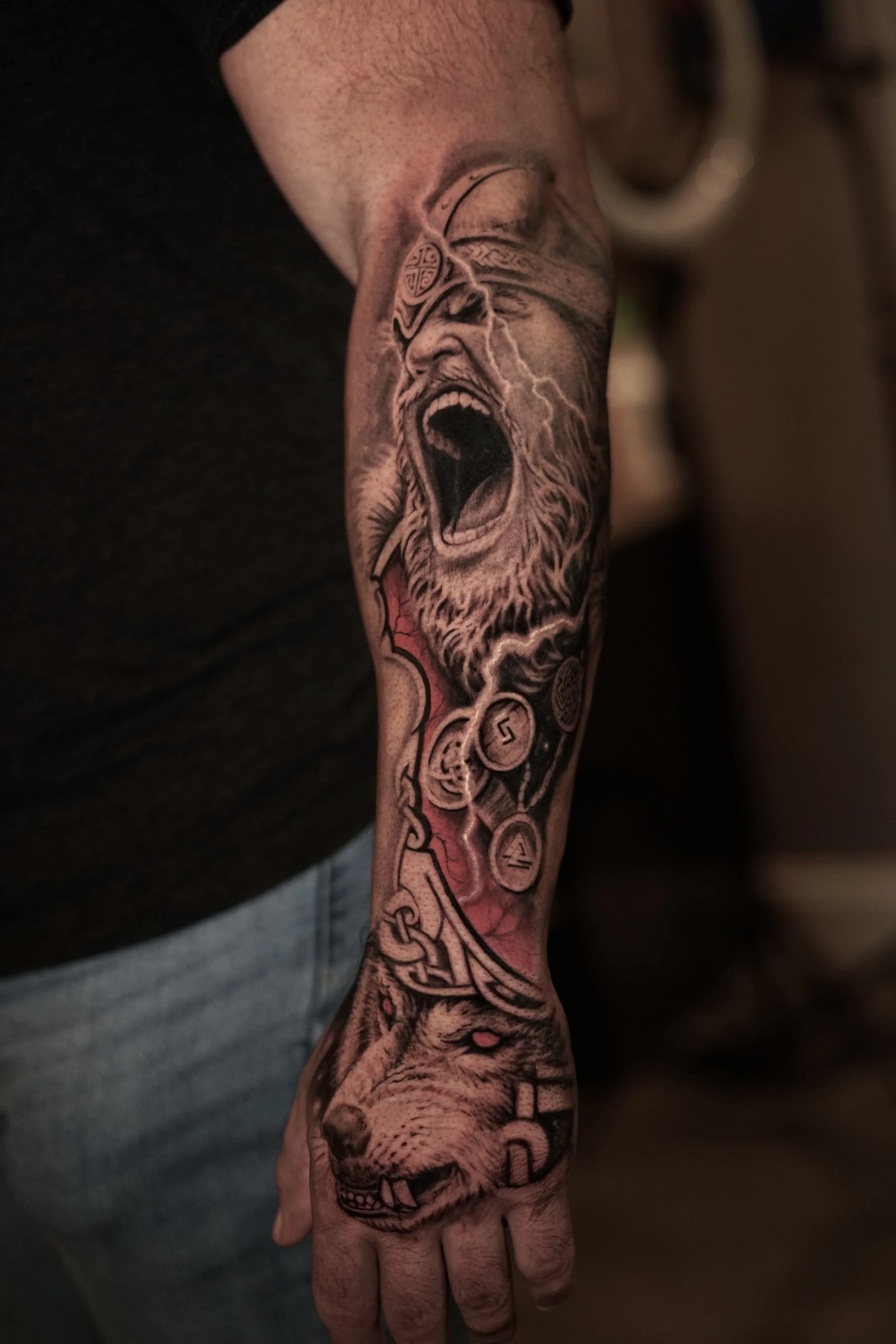 Detailed black-and-gray roaring lion arm tattoo at Black Craft Tattoo Collective.