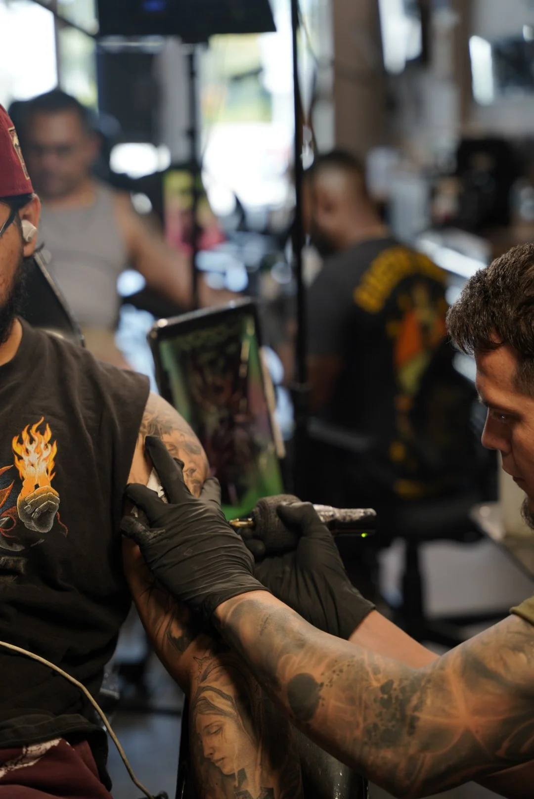 Tattoo artist working on a client’s upper arm inside Black Craft Tattoo Collective.