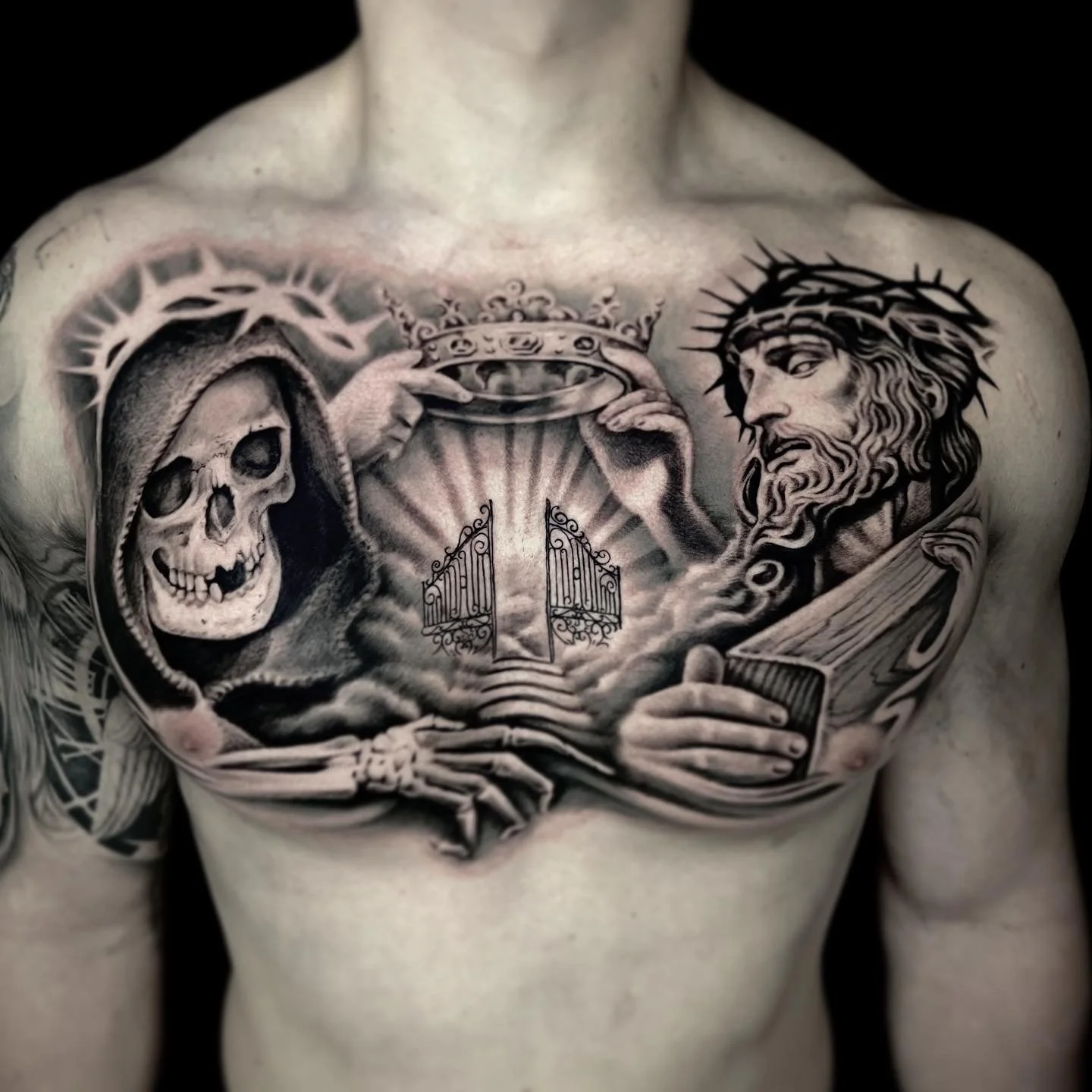 Black-and-gray Jesus, hooded skull and illuminated gate tattoo by Luis Dajer.