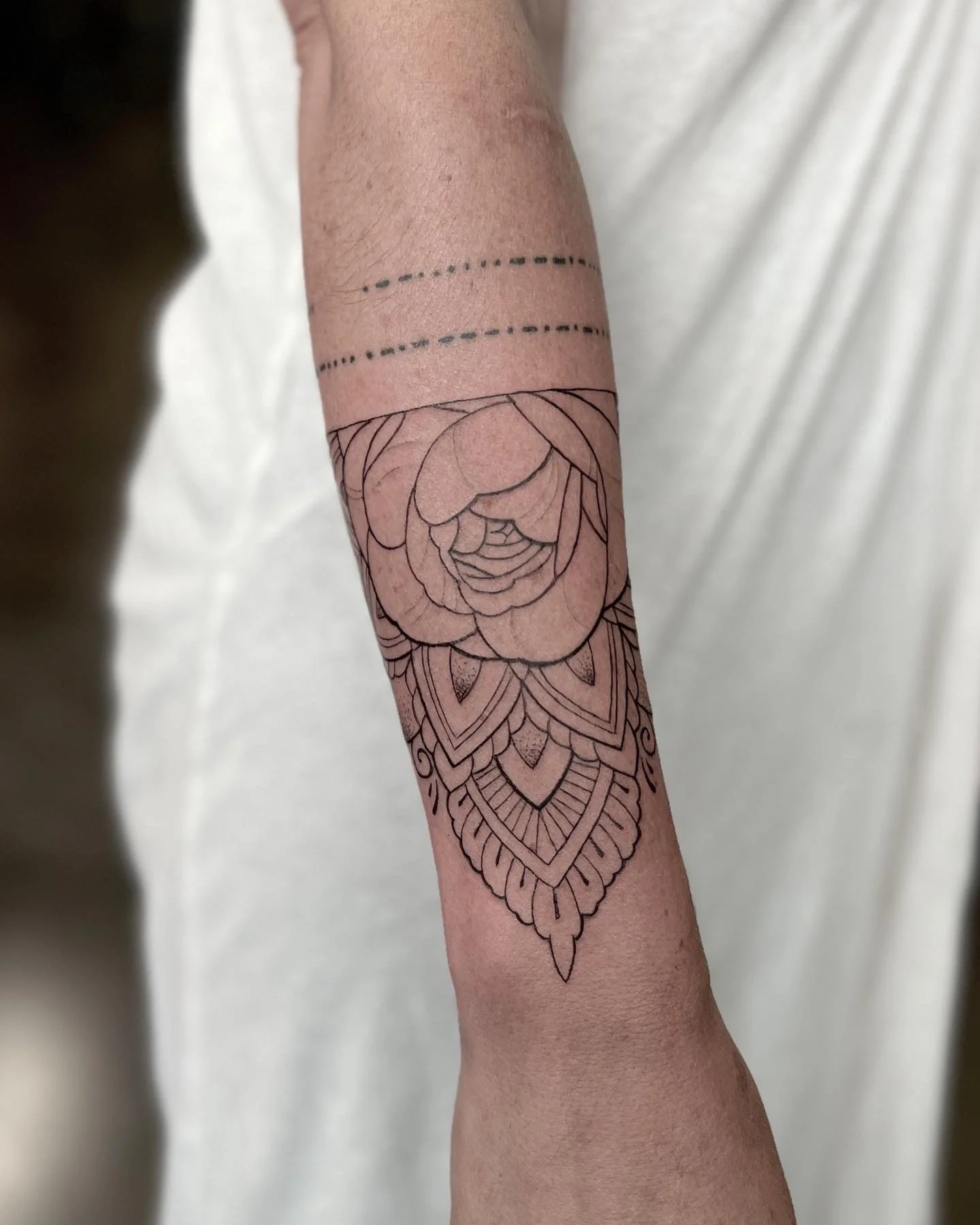 Fine-line floral and mandala arm tattoo by Luis Dajer in Charlotte, NC.