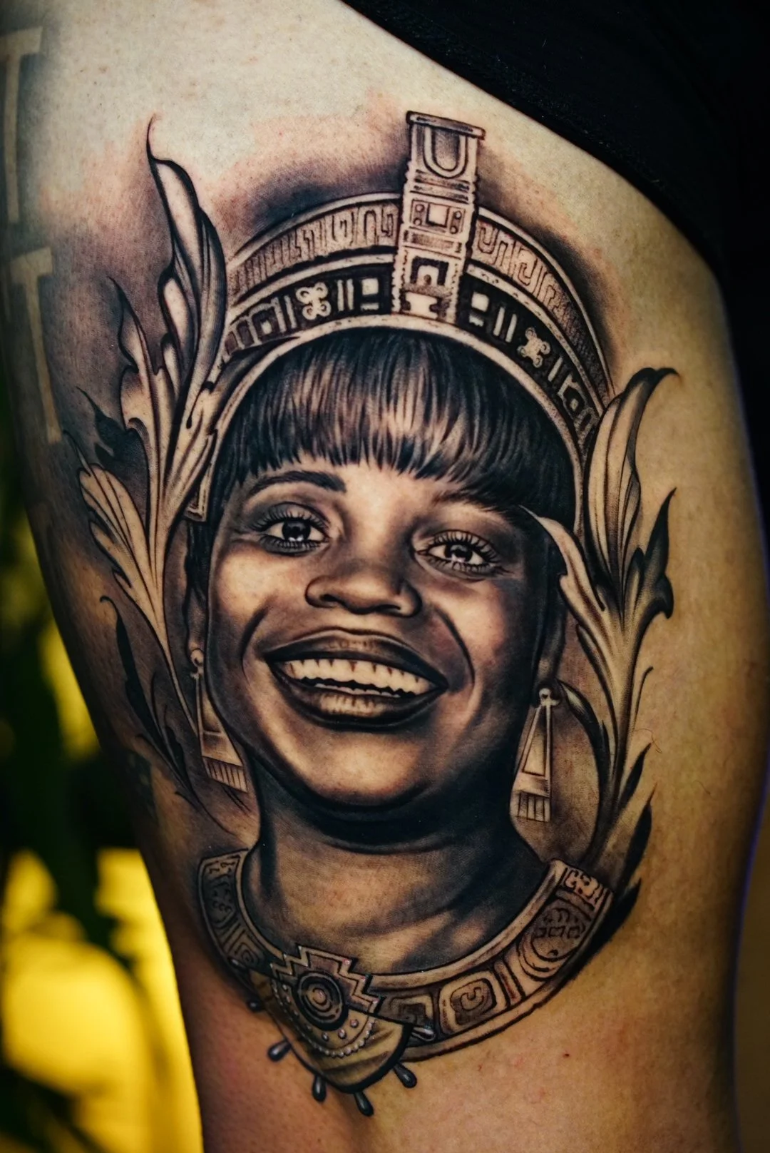 Realistic black-and-gray smiling child portrait with ornamental details.