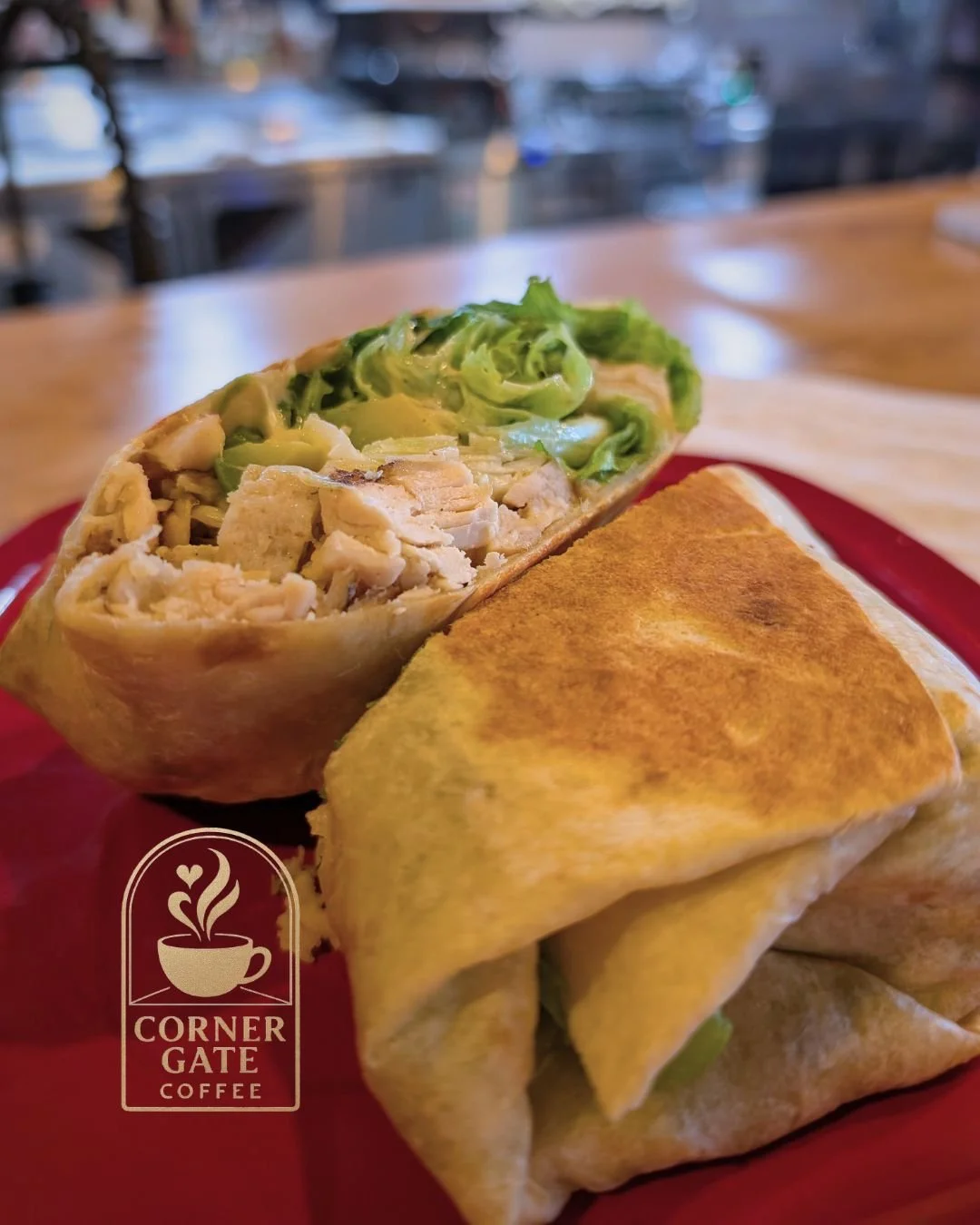 A close-up of a chicken burrito with shredded lettuce, served on a red plate at Corner Gate Coffee.