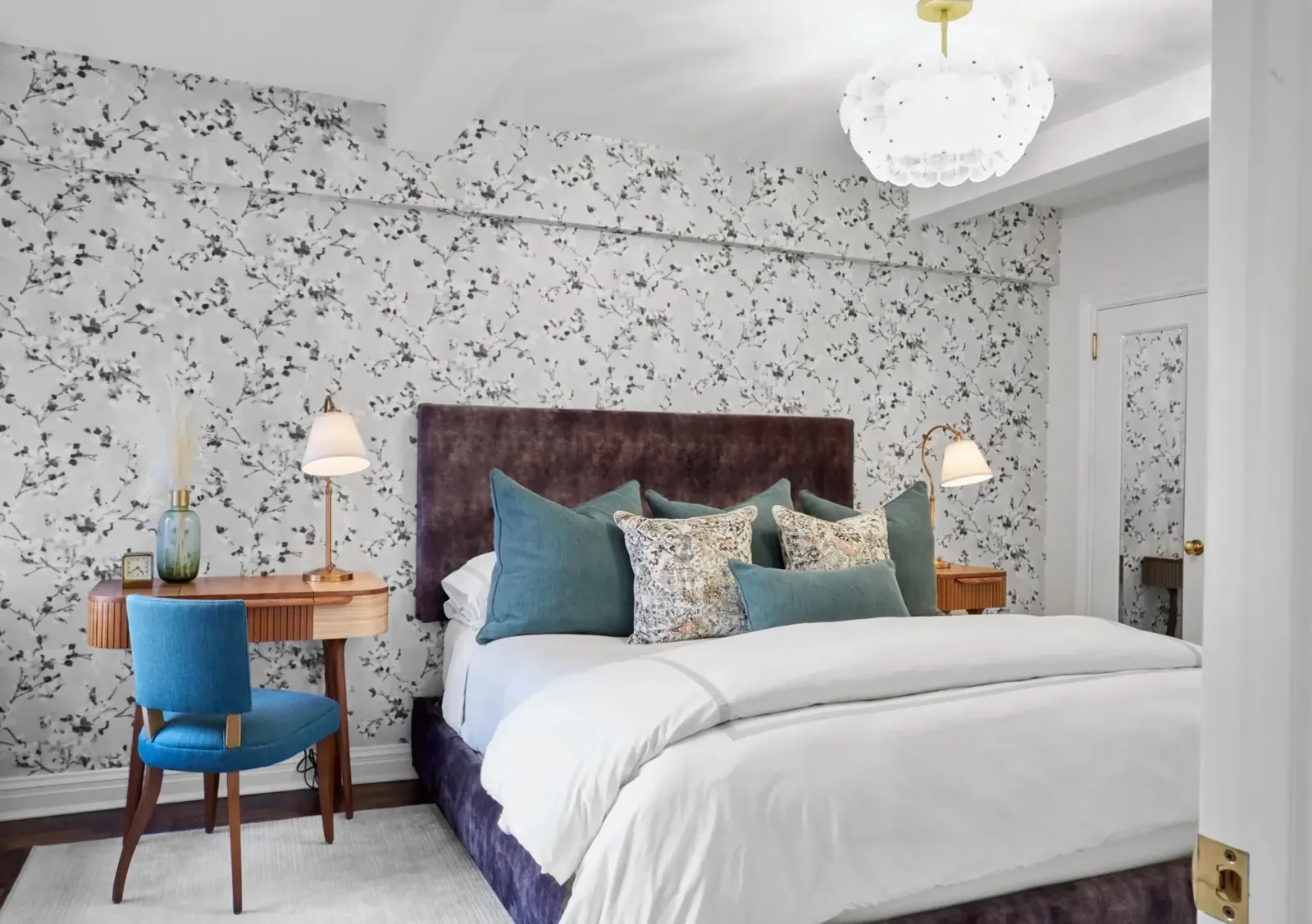 Wallpaper installation and decorative finishes in a model apartment bedroom.