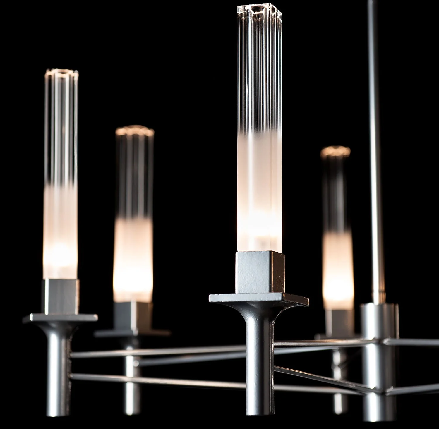 Close-up of modern electric lamps with transparent glass tubes on a black background.