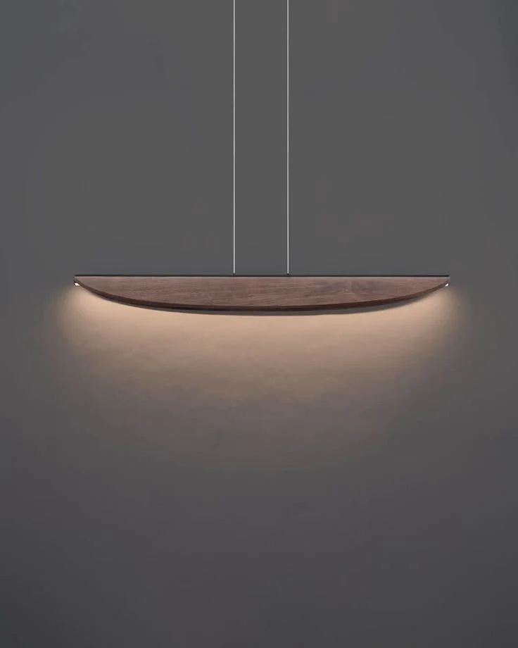 A modern, minimalist wall-mounted wooden light fixture with an LED light illuminating downward on a gray wall.