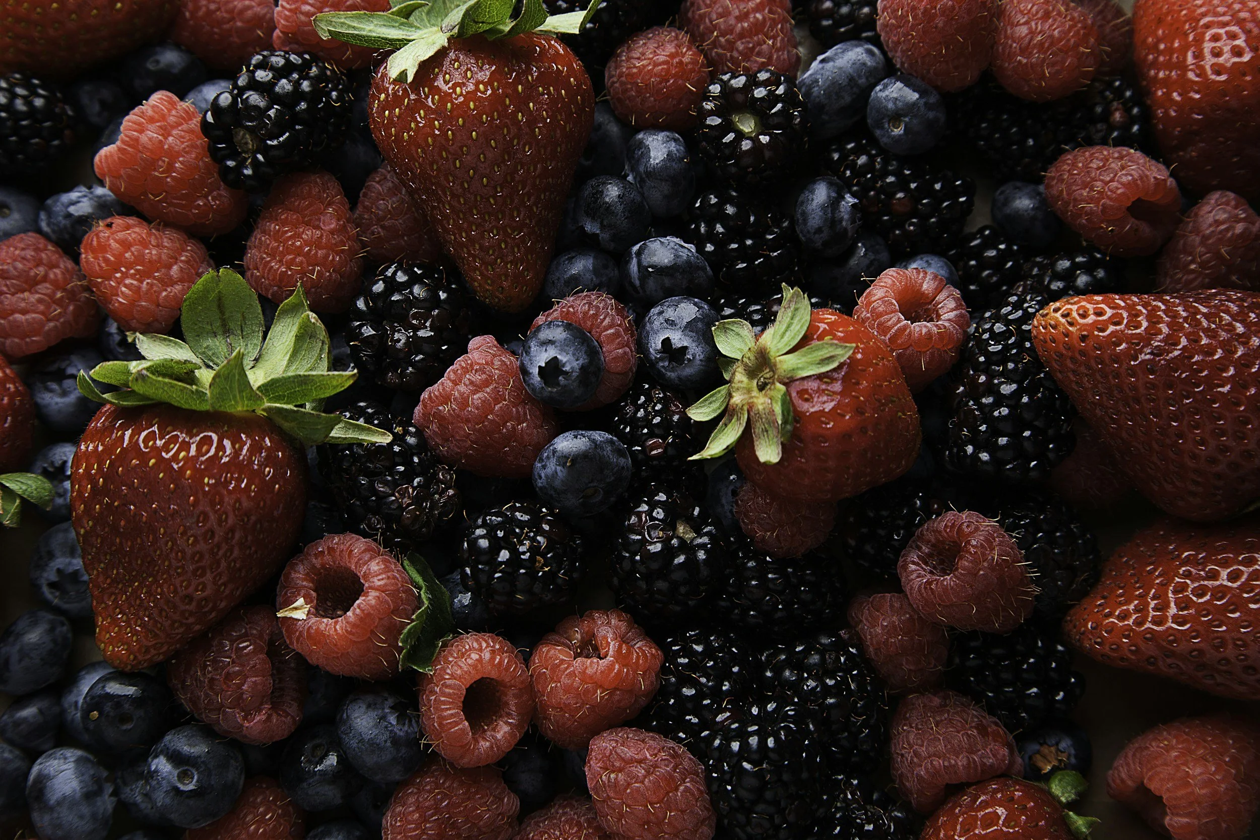 A collection of fresh mixed berries, including strawberries, raspberries, blackberries, and blueberries.