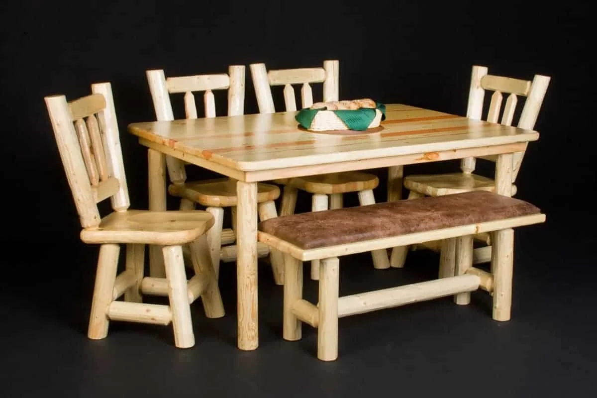 Miniature wooden dining table with five chairs and a bench, set against a black background.