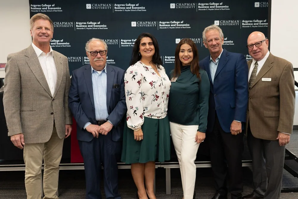 Summit organizers and leaders in front of the Chapman University backdrop
