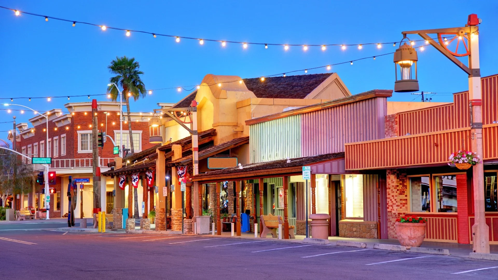 Evening view of Old Town Scottsdale with illuminated storefronts, outdoor dining, and historic Western architecture.