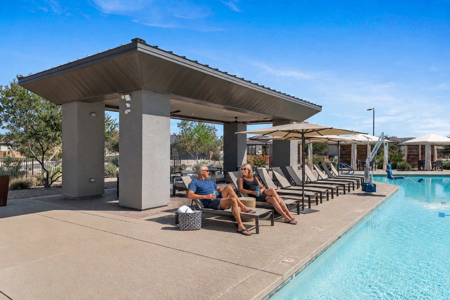 Residents relaxing beside the resort-style pool and shaded ramada at Ovation at Meridian.