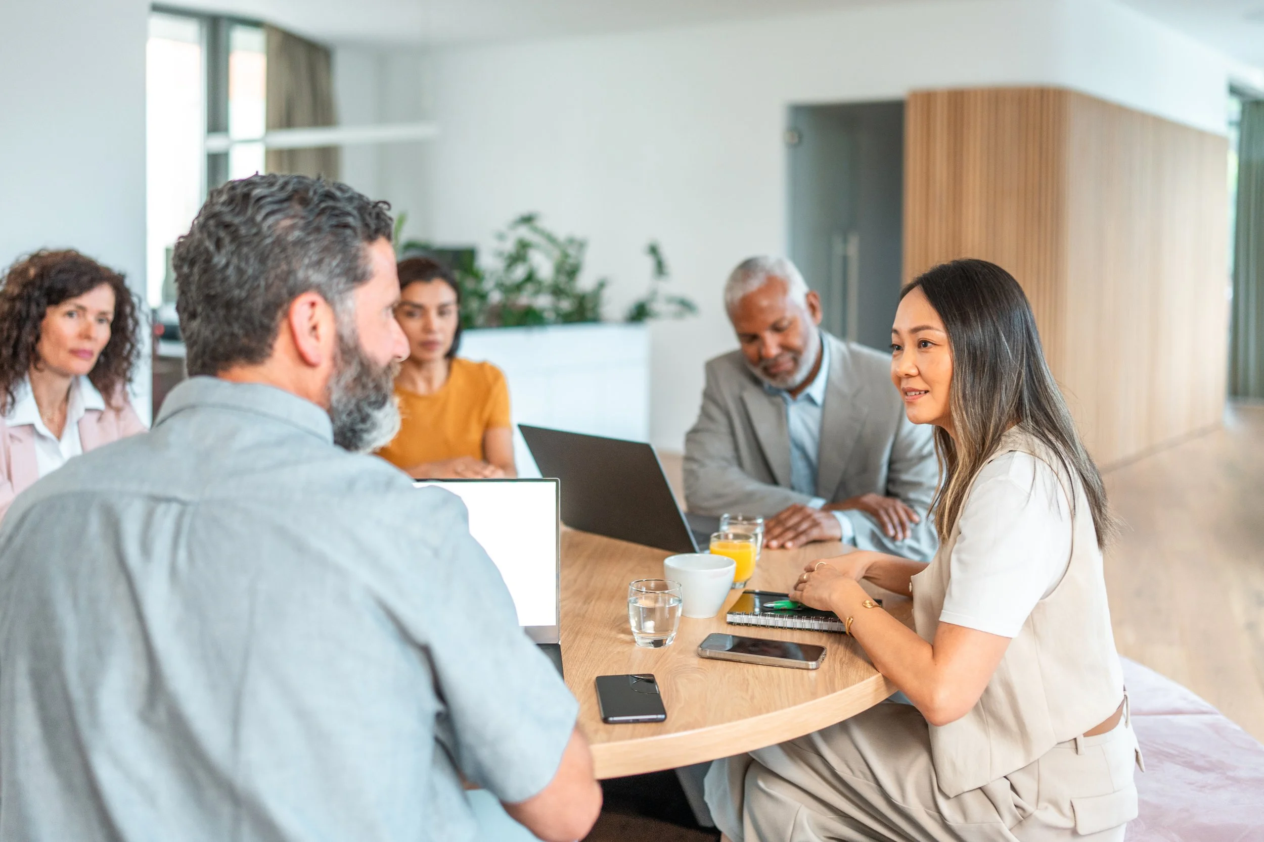 Five professionals in discussion around a round table