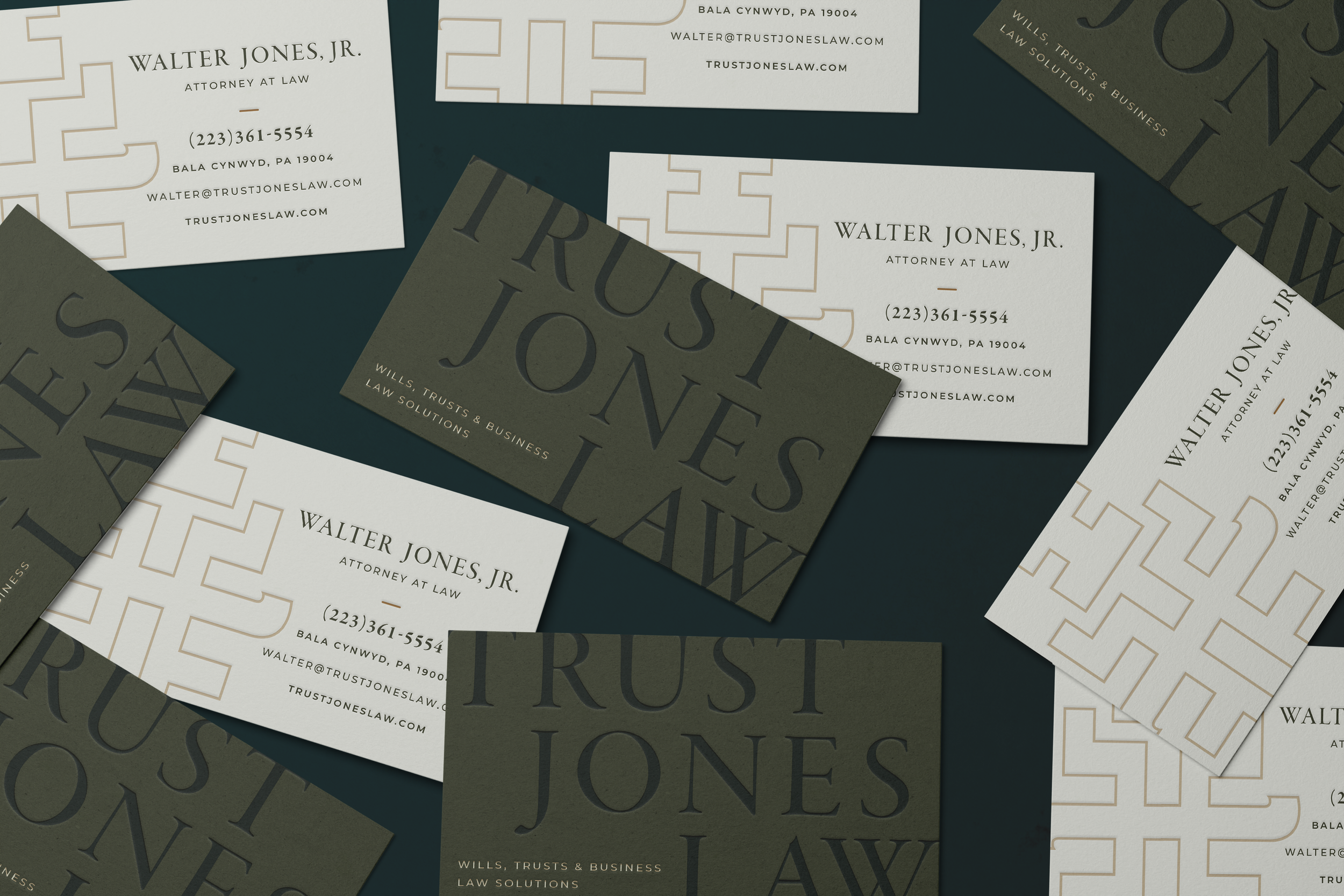 A collection of business cards for Walter Jones Jr., an attorney at law, arranged on a dark surface. The cards feature different designs, including white, dark green, and beige backgrounds with text displaying contact details and website information.