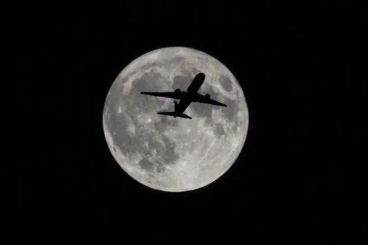 Airliner passing Moon