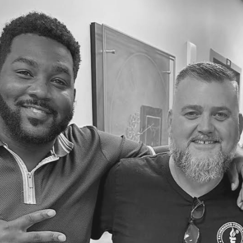 Two men posing for a picture smiling
