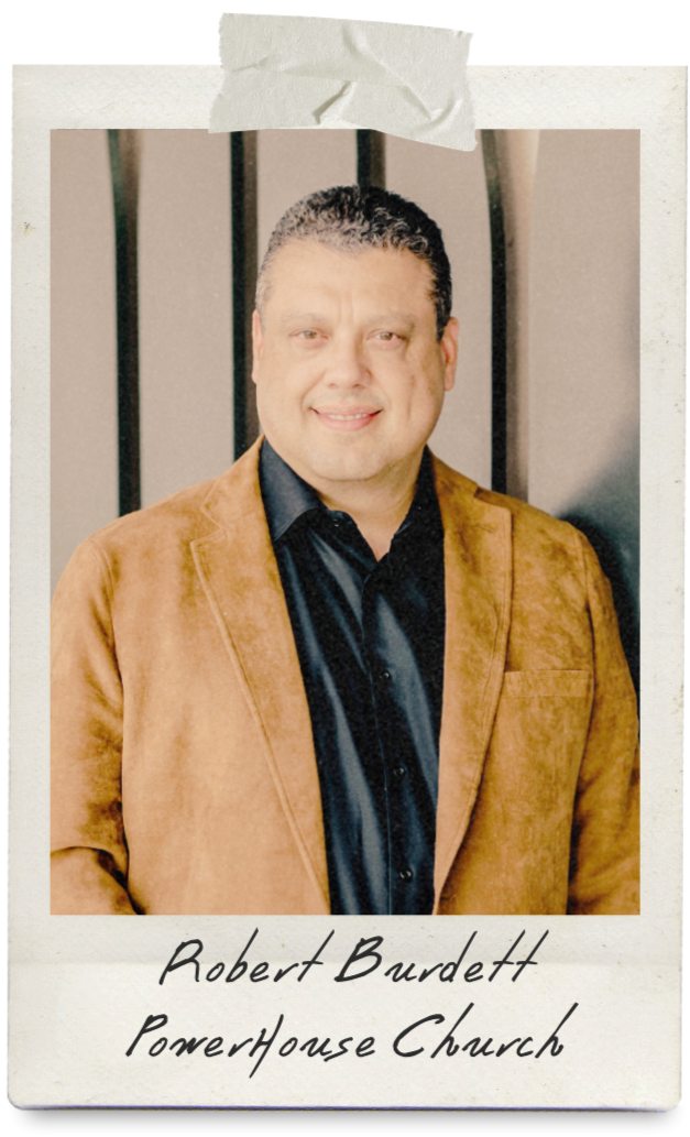 A pastor wearing a suit smiling