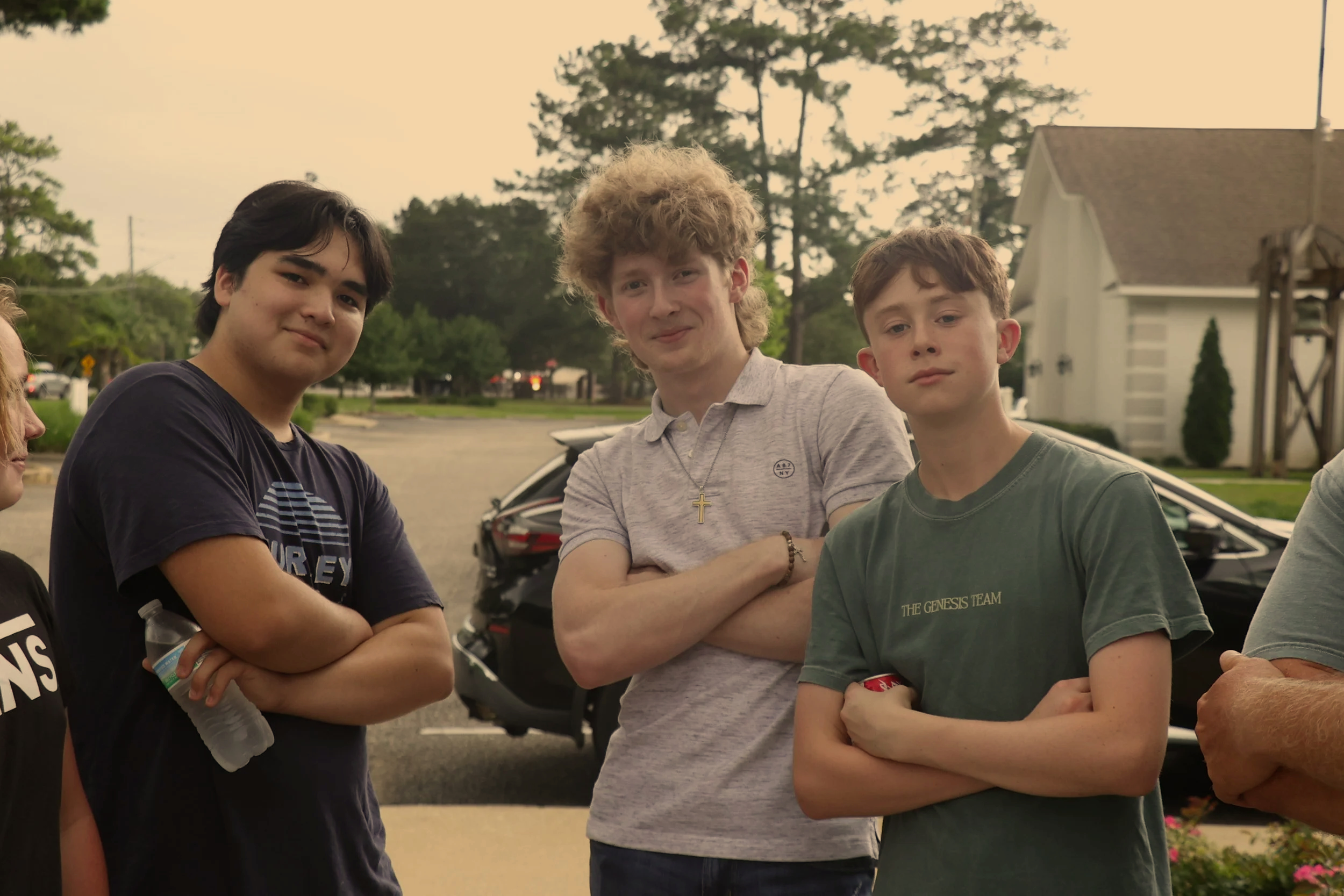 Three youth males posed outside smiling