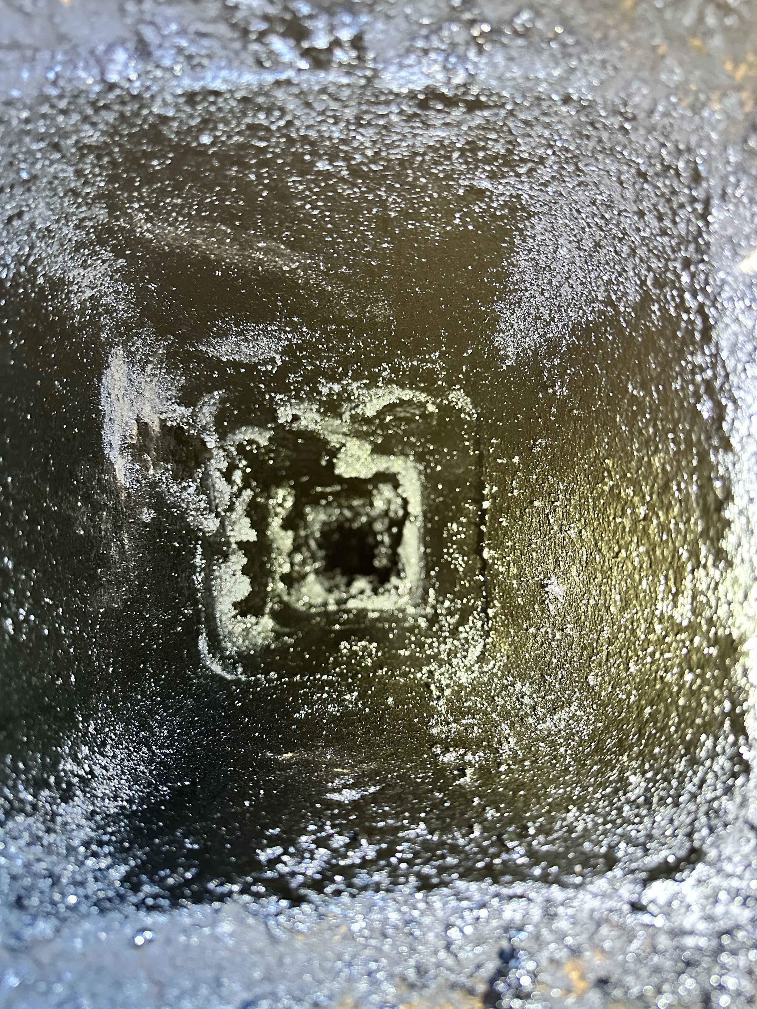 Gouttes d'eau gelée formant un tunnel ou un vortex en cristal, avec une lumière douce et refractée.