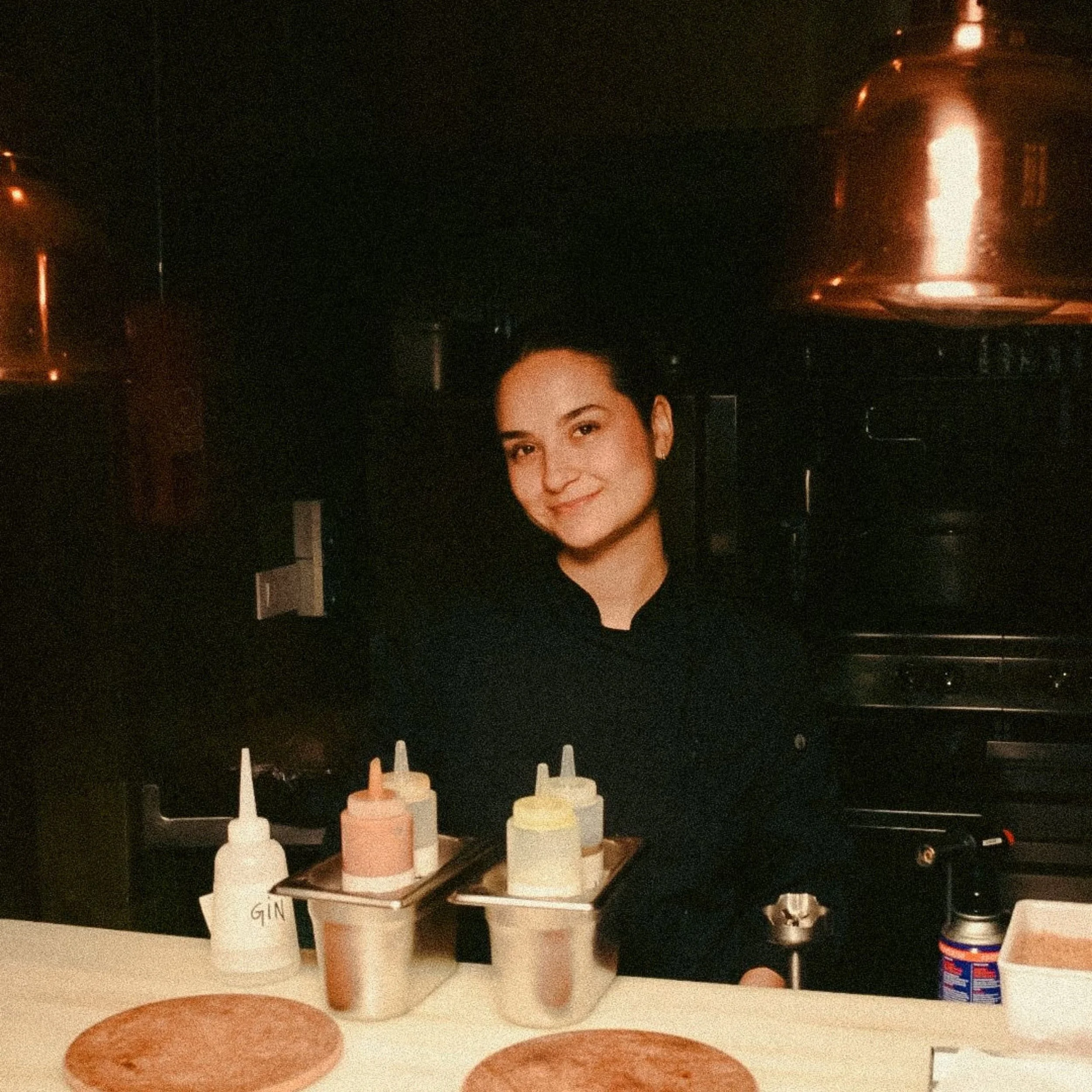 Professional portrait of chef Bella, owner of Bella Cooks, smiling in a clean chef uniform