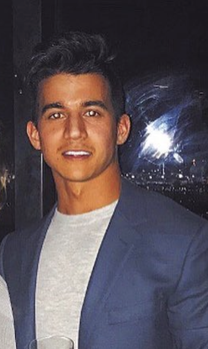 Image of Kevin Catapang, of Infusion Insurance, wearing a blazer over a T-shirt, smiling at the camera at night.