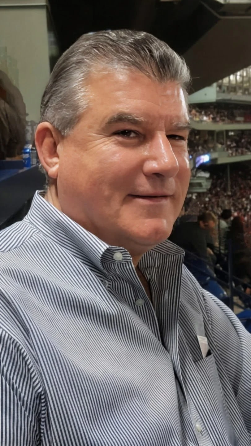 Steve Crispo wearing a striped shirt at a sporting event