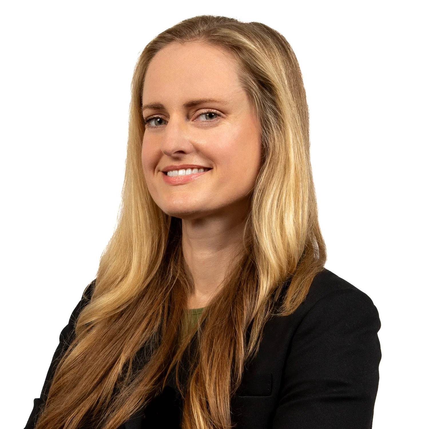 A woman with long, wavy blonde hair, wearing a black blazer, smiling, against a white background.