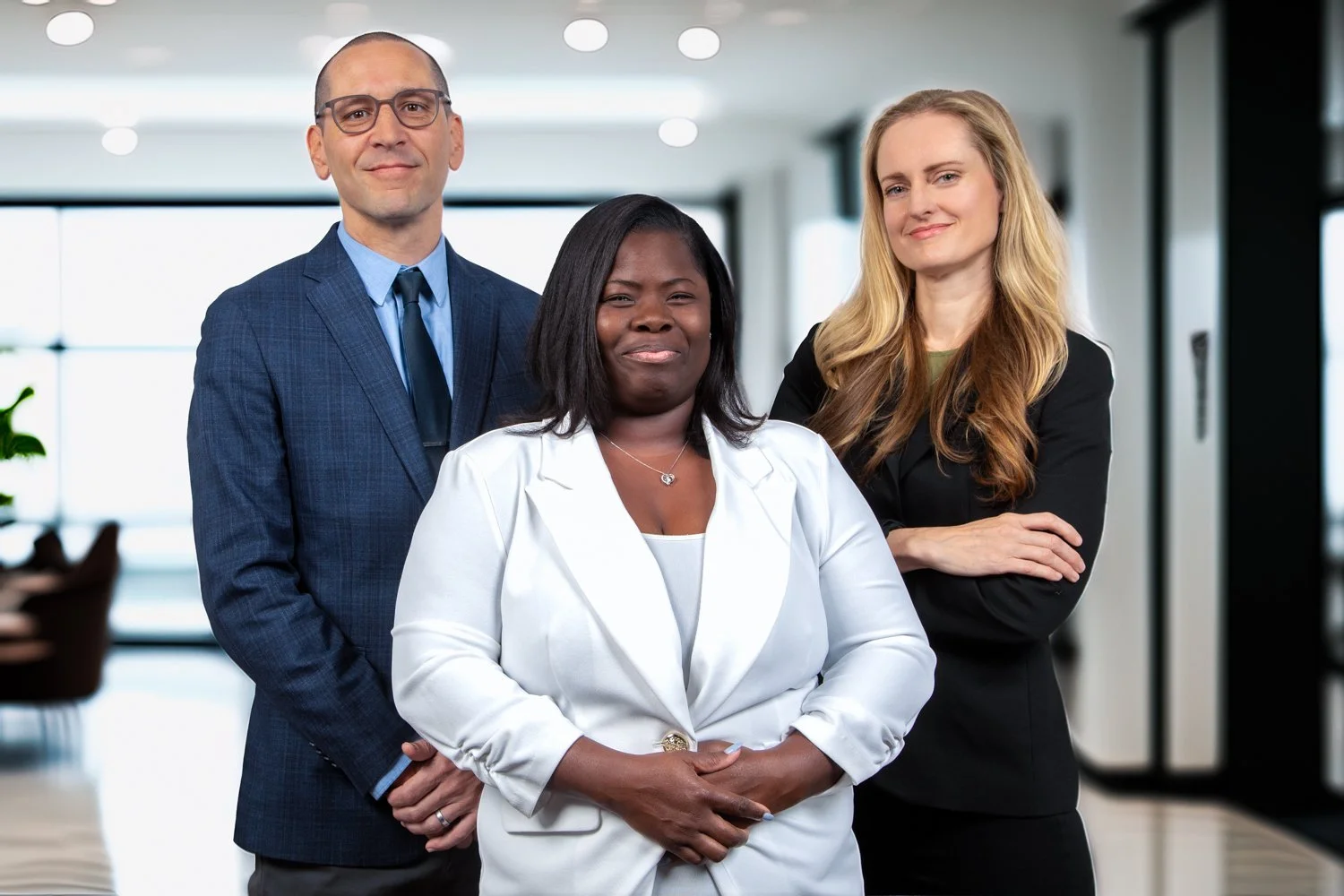 three people standing in a brightly lit law office