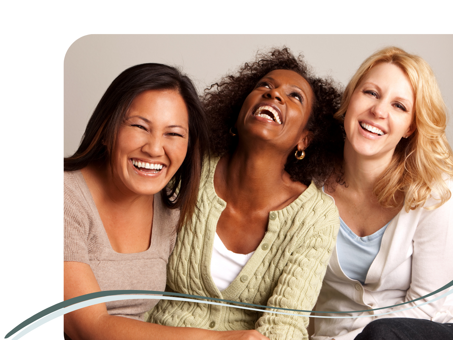 Three women laughing together, close-up portrait, diverse ethnicities, casual clothing, smiling happily.