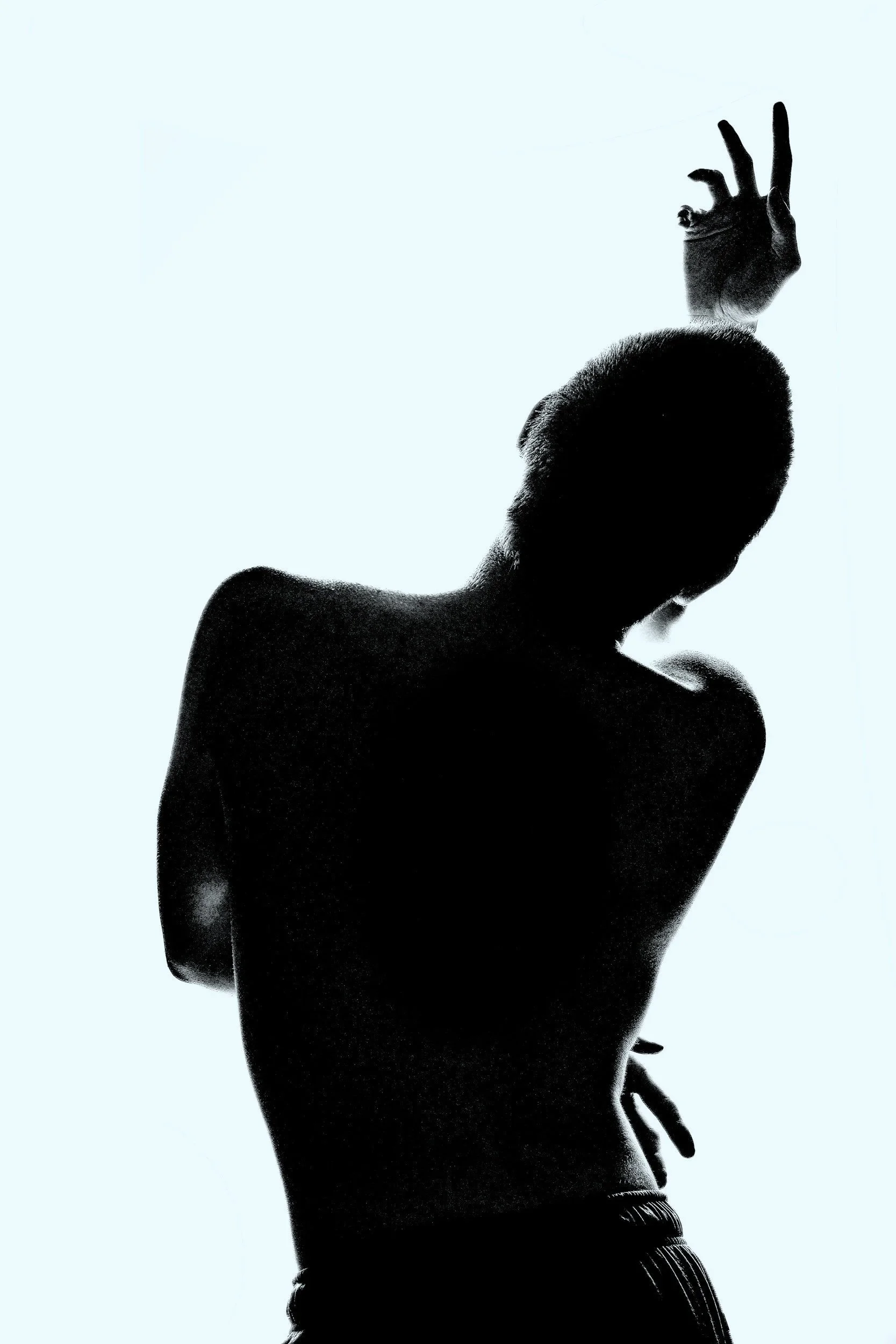 Silhouette of a person with a muscular upper body, raising one hand with fingers forming an 'OK' gesture, against a light background.