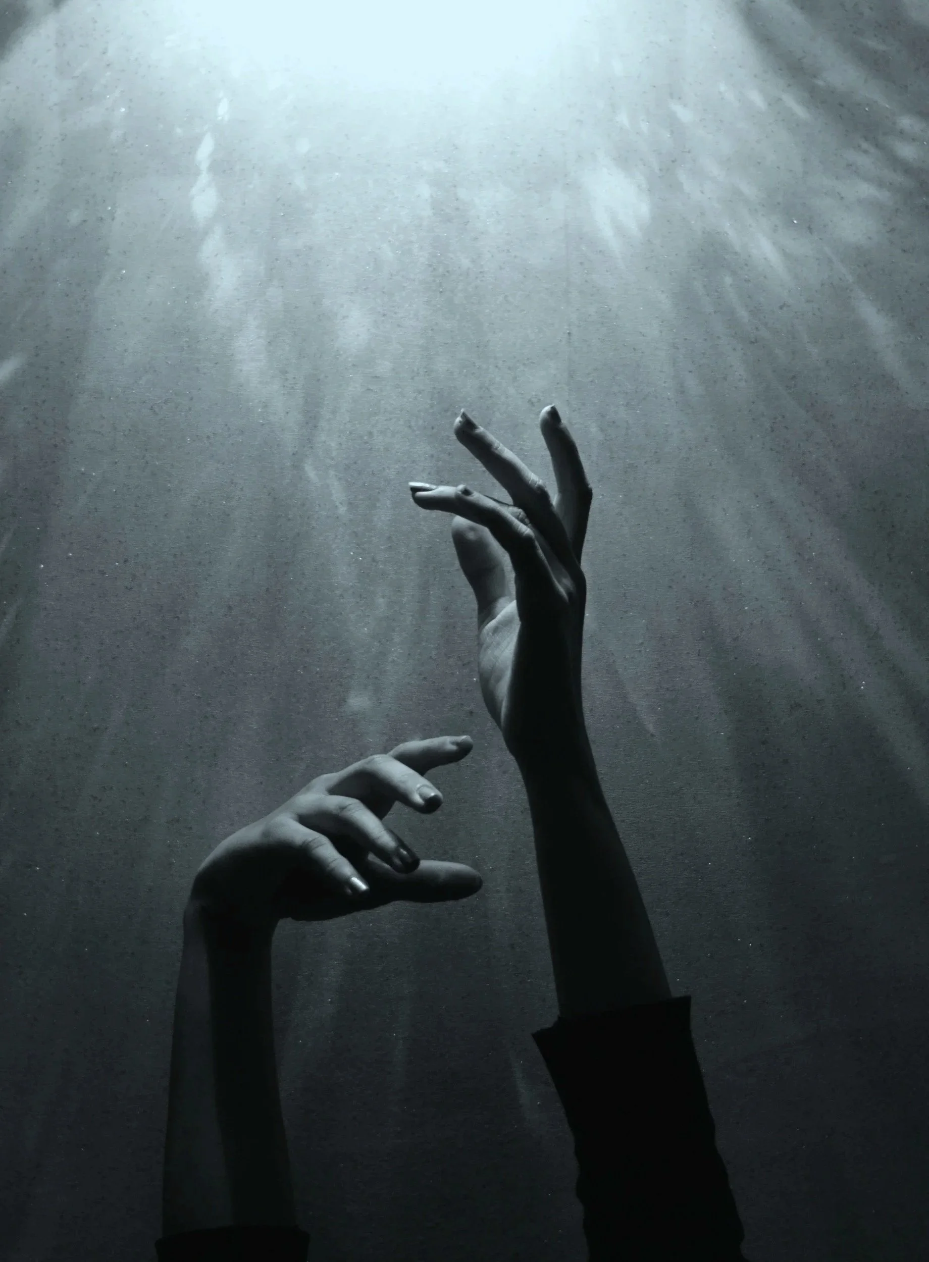 Black and white photo of a person's hands and arms reaching up towards the light, with the background being a textured surface.