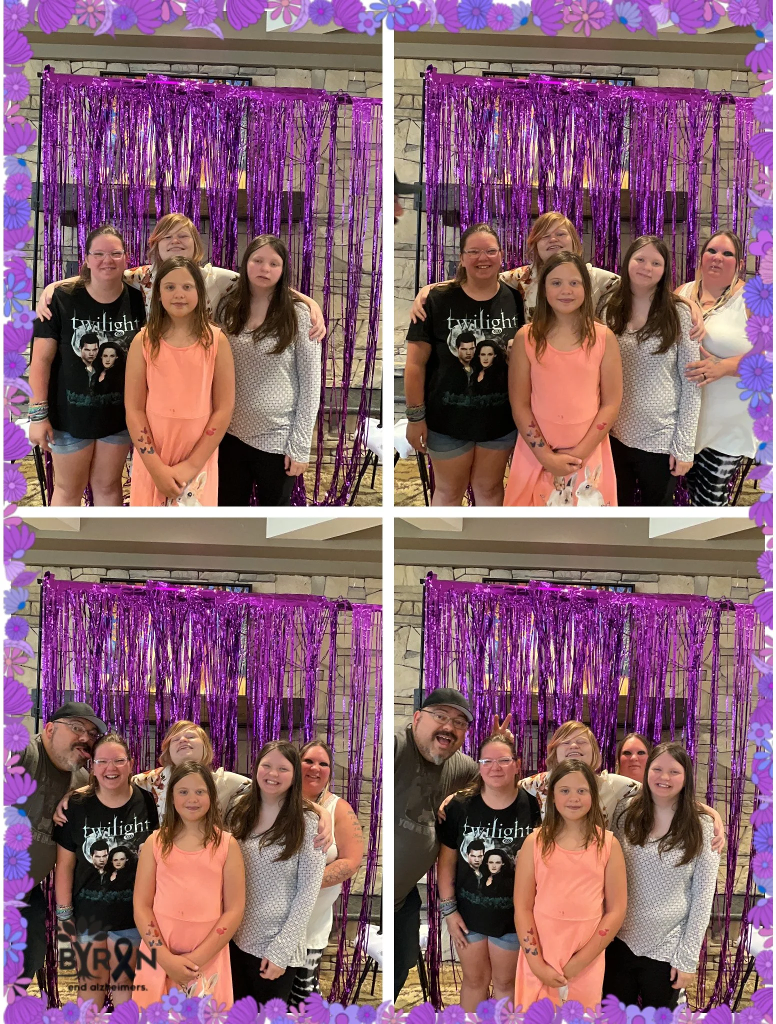 Family and friends posing in front of purple tinsel backdrop at an indoor event, some making peace signs and wearing casual clothing.