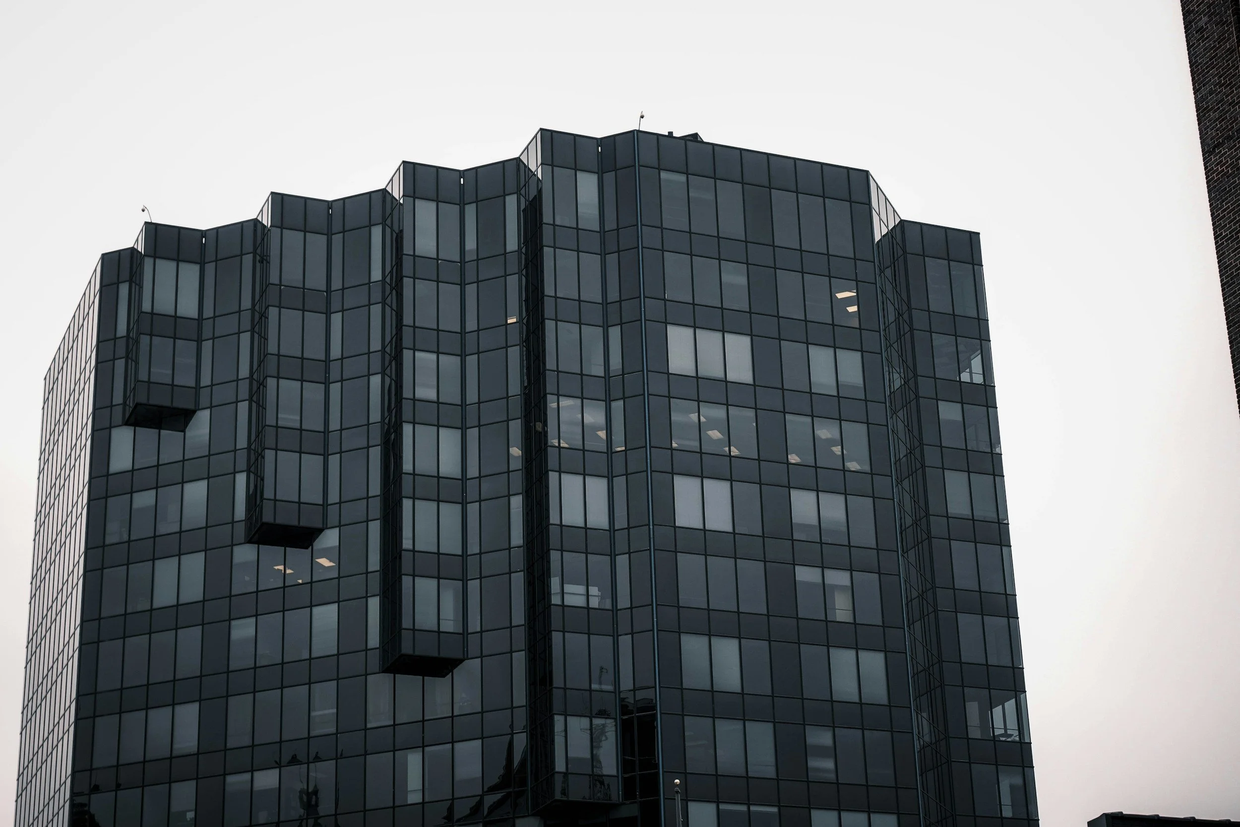 Contemporary commercial building featuring a modern glass exterior with large transparent panels, sleek architectural design, and reflective glass facade.