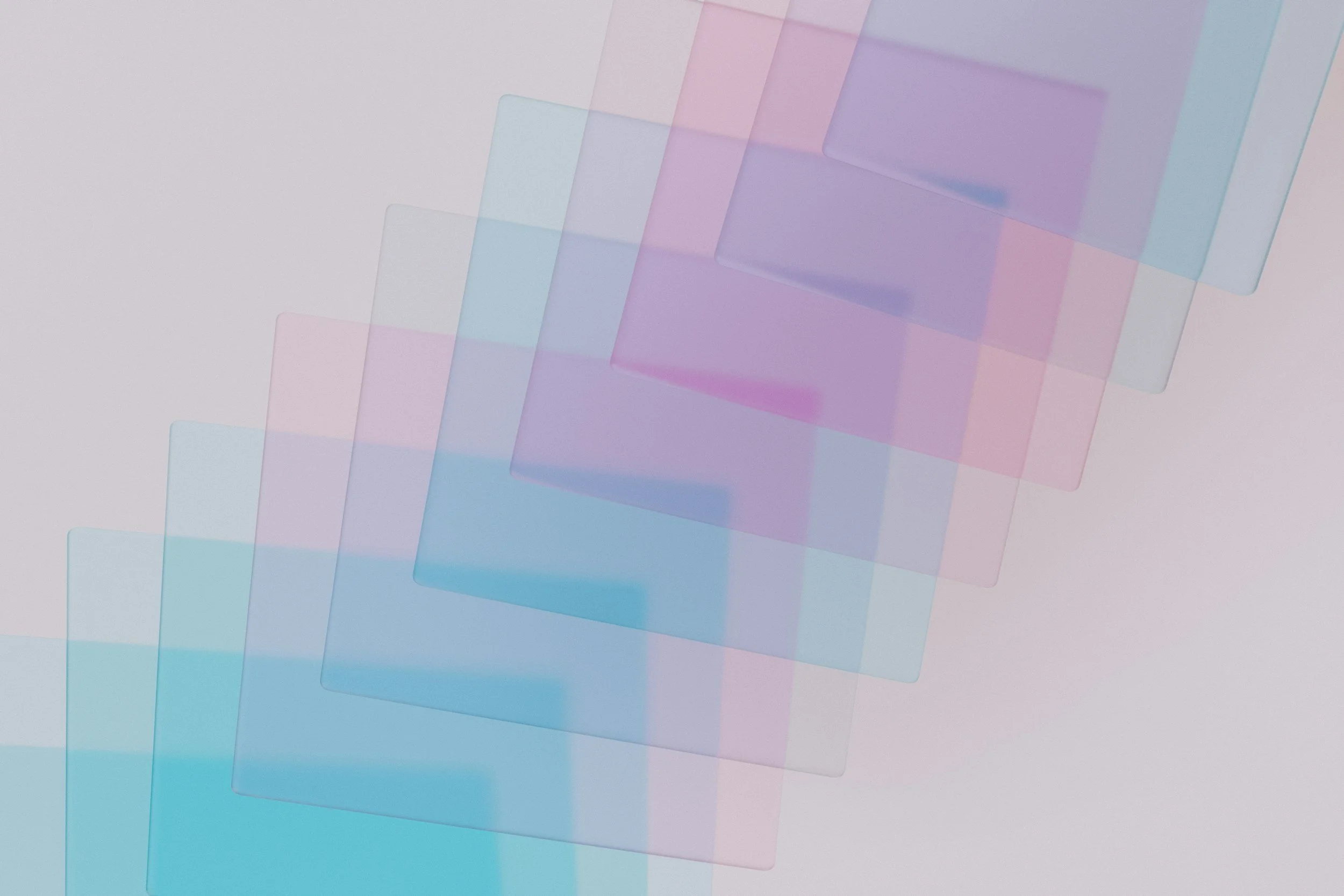 Abstract image of overlapping semi-transparent rectangles in pastel colors including pink, blue, purple, and teal, arranged diagonally on a light background.