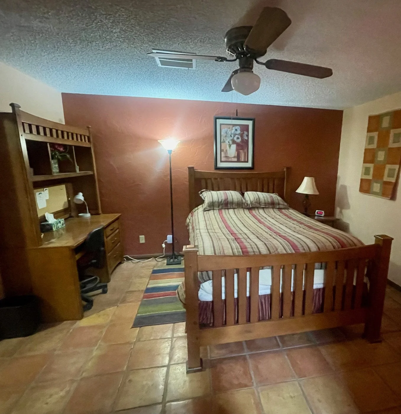 Master Bedroom

Spacious Primary Suite with Queen Bed
The primary bedroom offers a peaceful retreat featuring a comfortable queen-size bed, warm Southwestern décor, and a dedicated workspace. Rich wood furnishings, Saltillo tile flooring, and soft li