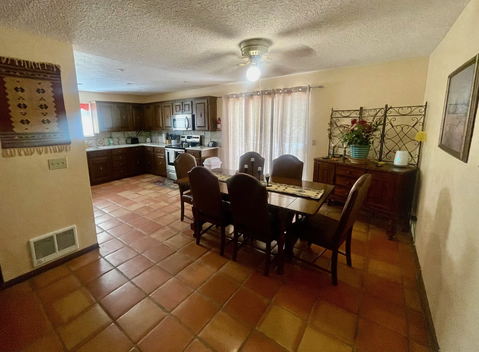 Open Dining & Kitchen Area

Perfect for Shared Meals and Conversation
The open dining room flows seamlessly into the kitchen, creating a welcoming gathering space for family meals, game nights, and memorable conversations. Southwestern décor and warm