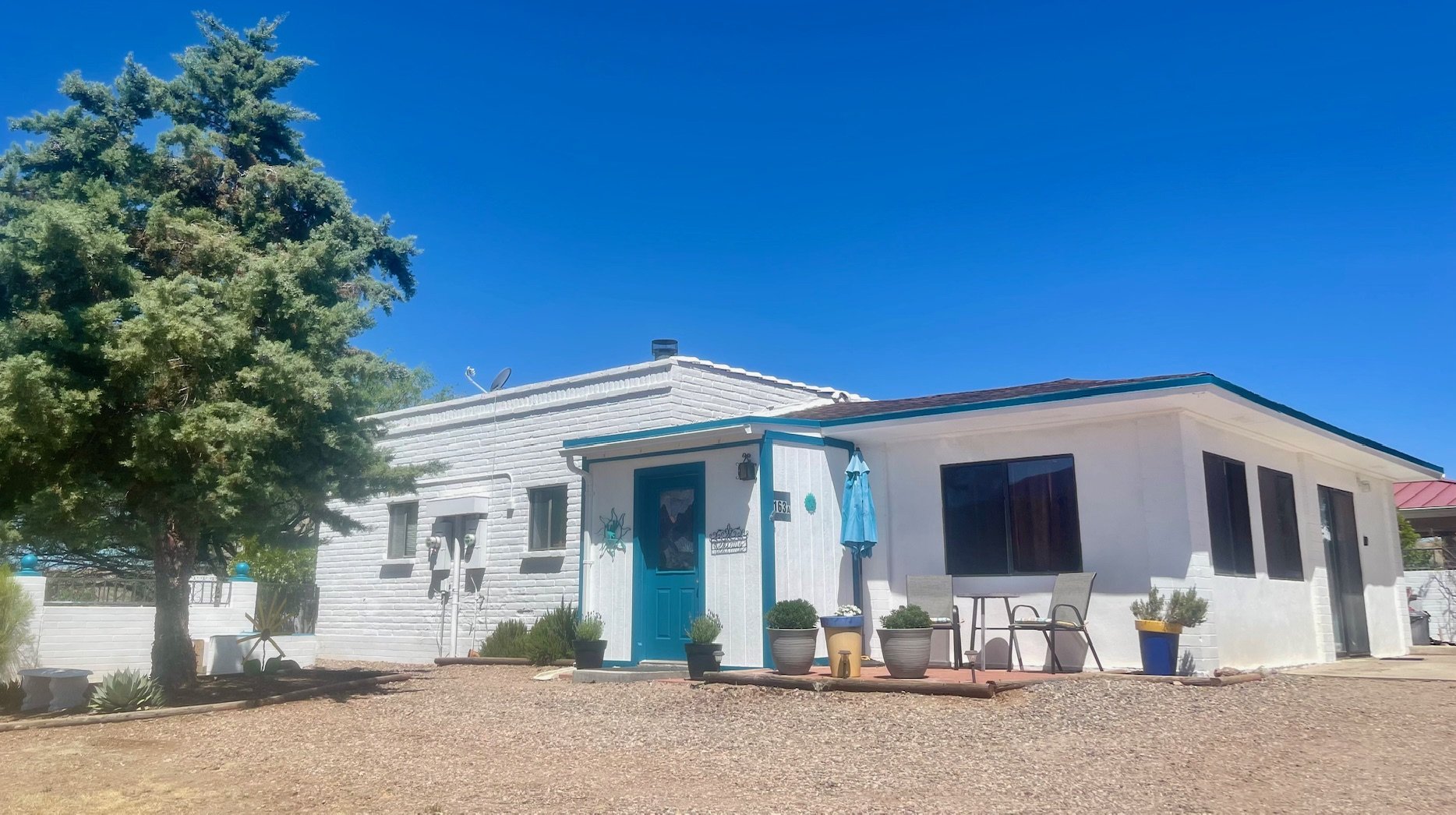 Front Exterior

Welcome to Roadrunner Retreat at Red Mountain
Your desert getaway begins here. This charming Southwestern hacienda features classic white stucco architecture, vibrant turquoise accents, mature shade trees, and inviting outdoor spaces 