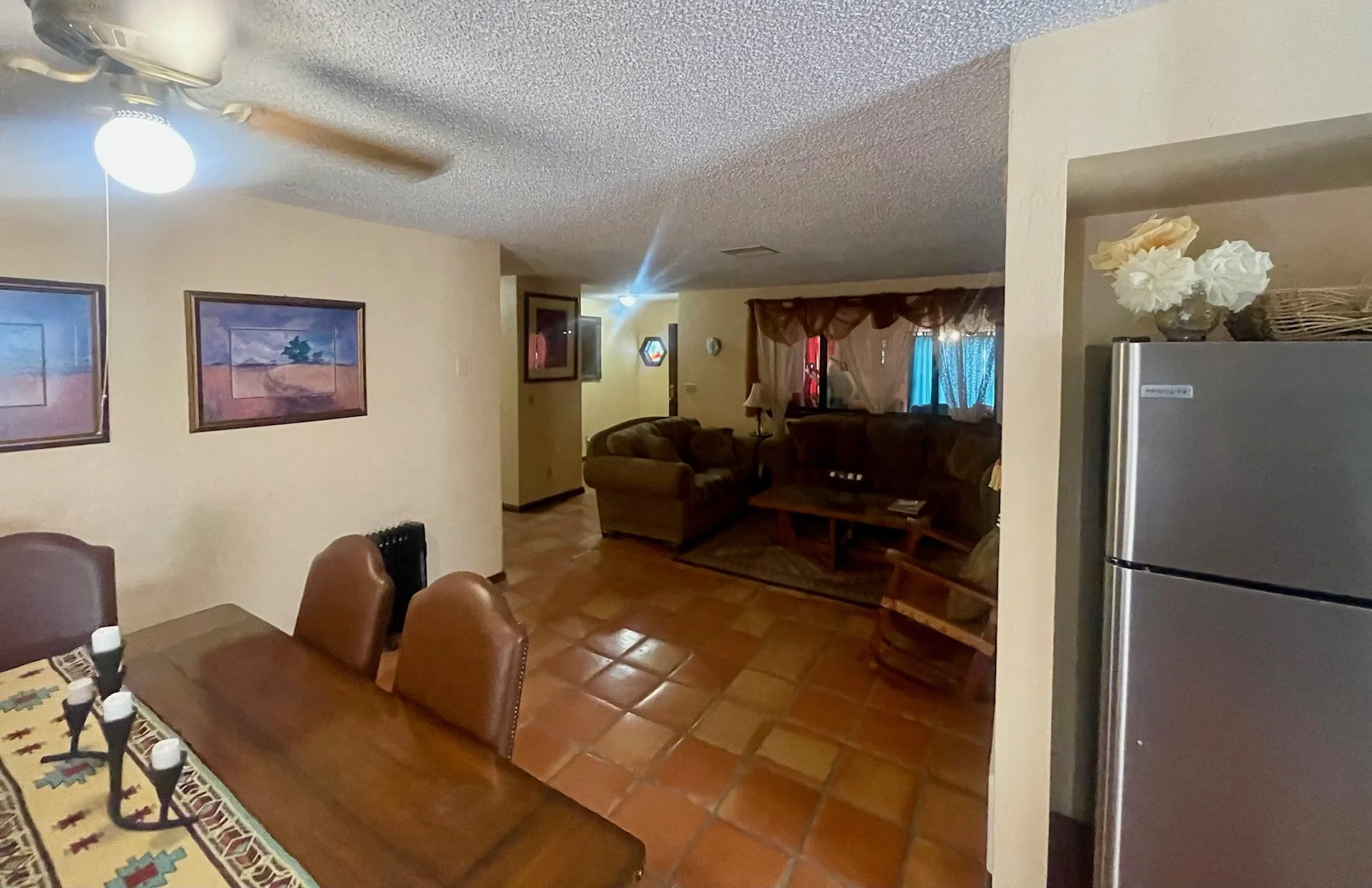 Open-Concept Living Space

Warm Southwestern Hospitality
The home's open floor plan connects the dining and living areas, creating an inviting atmosphere that encourages connection and relaxation. Rich wood accents, comfortable furnishings, and tradi
