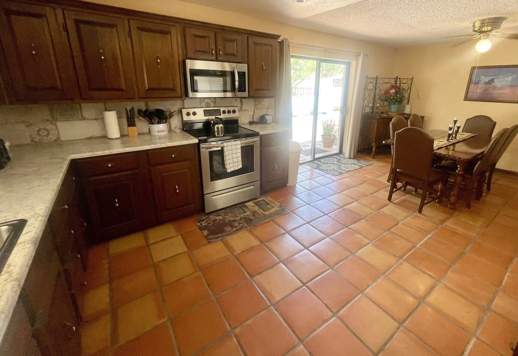 Kitchen & Dining Area

Spacious Southwestern Kitchen with Patio Access
The fully equipped kitchen features generous counter space, abundant cabinetry, modern stainless-steel appliances, and classic Saltillo tile flooring throughout. Adjacent to the k