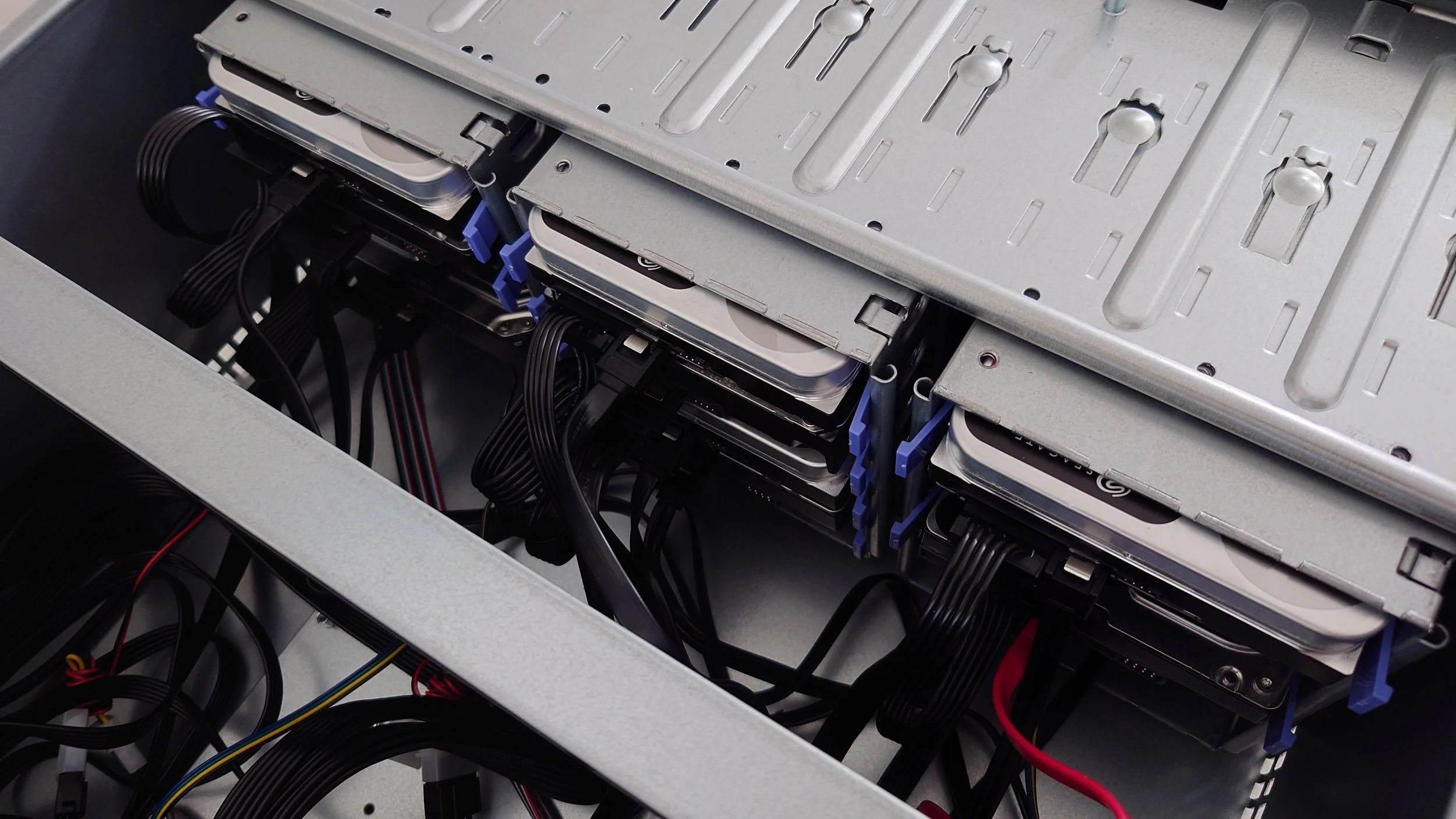 The interior of a media server with multiple hard drives installed and connected with cables.