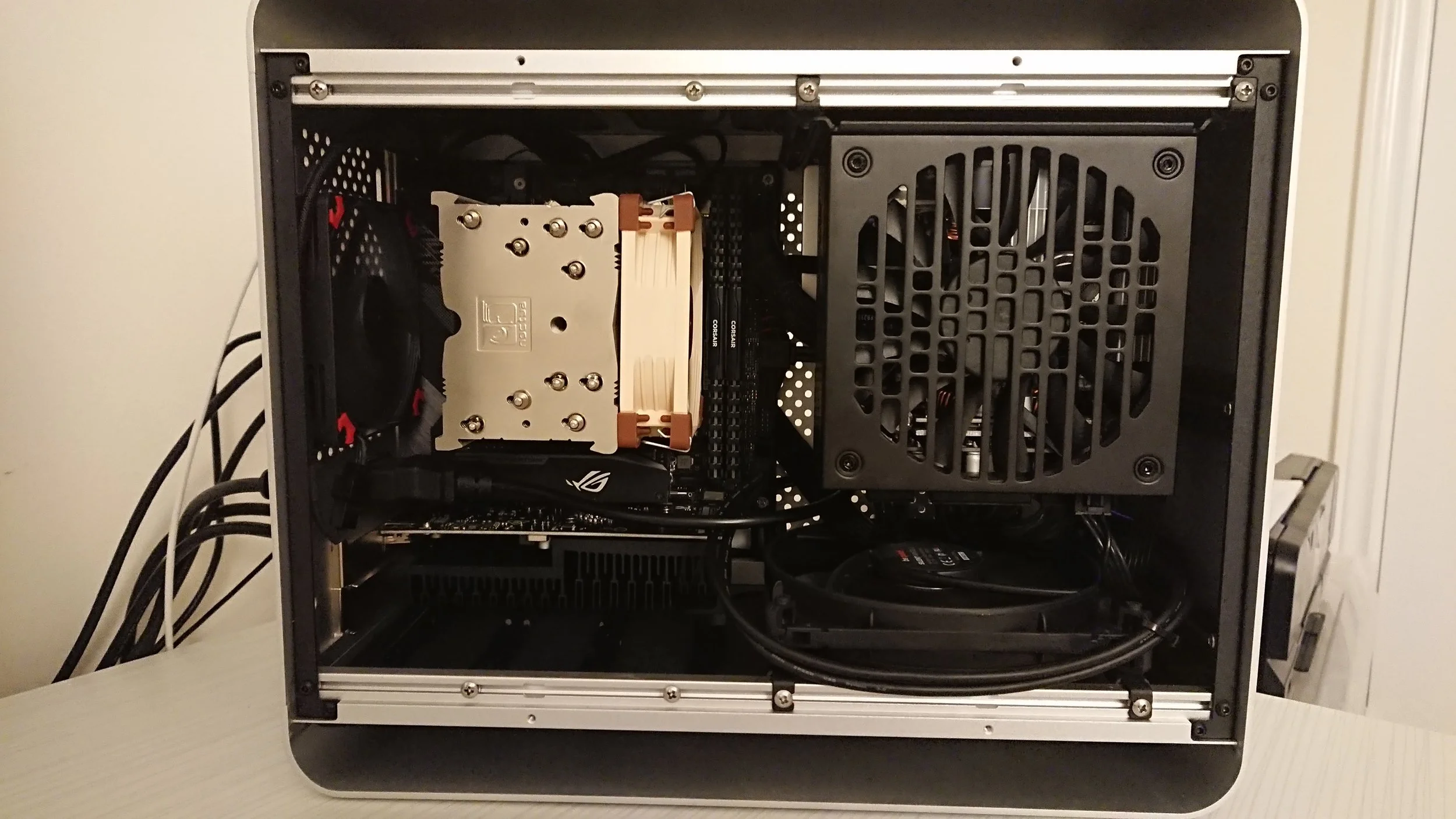 Open desktop computer case showing internal components including a CPU cooler, RAM sticks, power supply, and cables.