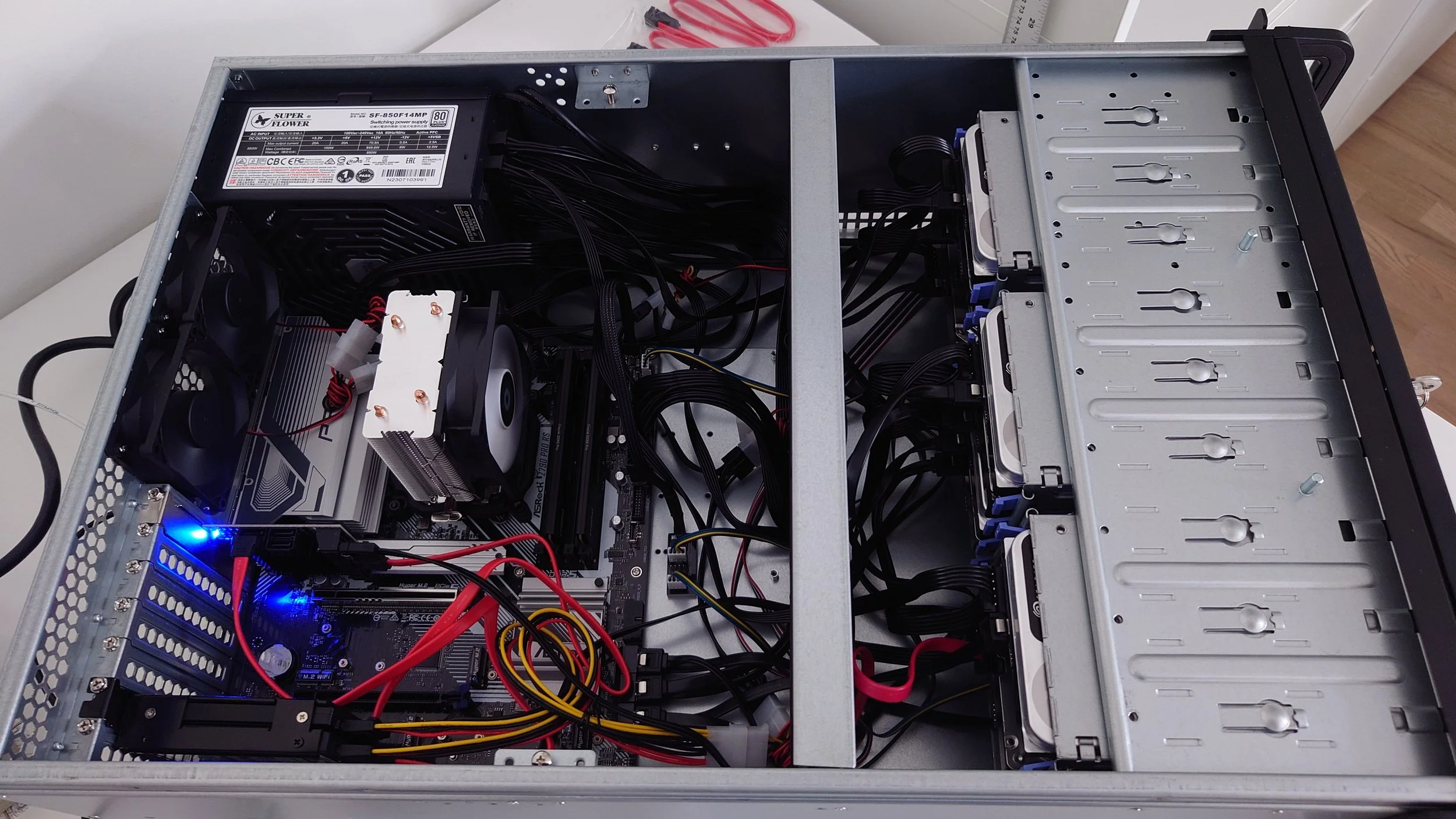 Inside view of a partially assembled computer case with various internal components, cables, and a power supply unit.