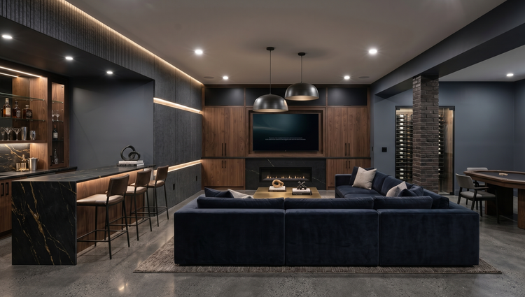 Modern luxury basement entertainment room with a wet bar, navy sectional sofa, wall-mounted TV, fireplace, wine cellar, and poker table