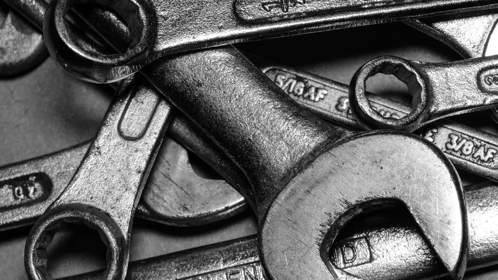 Close-up black-and-white photograph of metal wrenches and parts. Tools for kids. A show about tools for kids. 